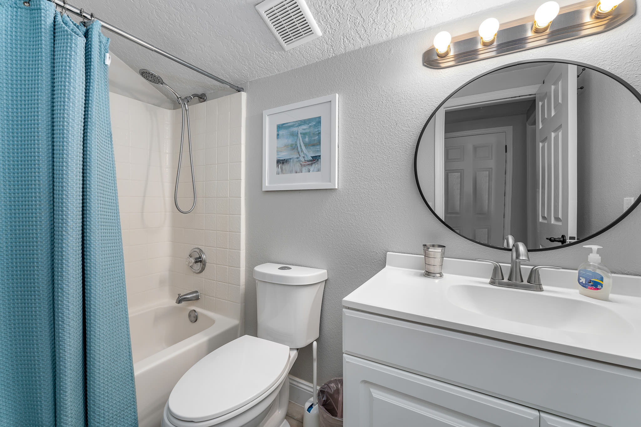 Bathroom w/ tub & shower combo, sink, and clean, modern finishes.
