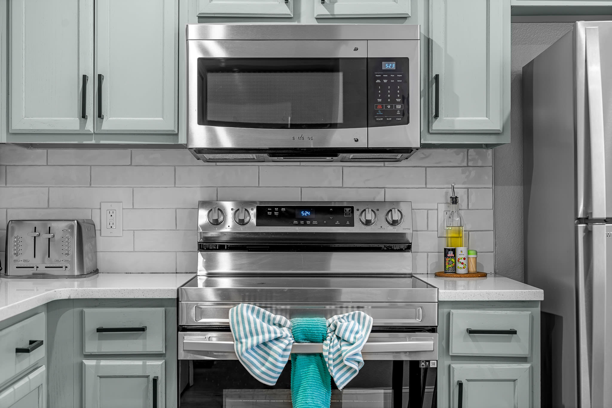 Well-equipped kitchen w/ microwave, oven, and neatly styled finishes.