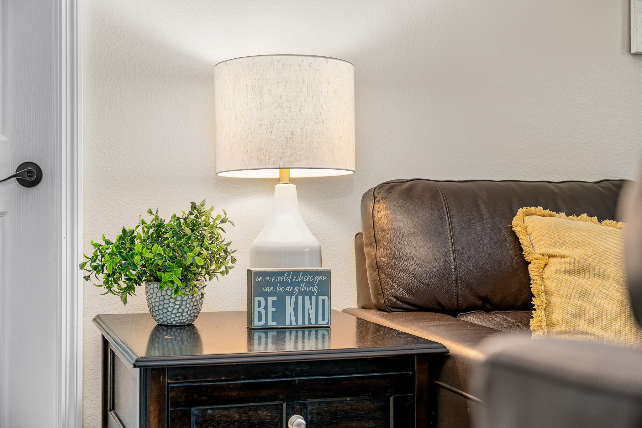 Comfortable bedroom seating area w/ soft lamp light and layered textures.