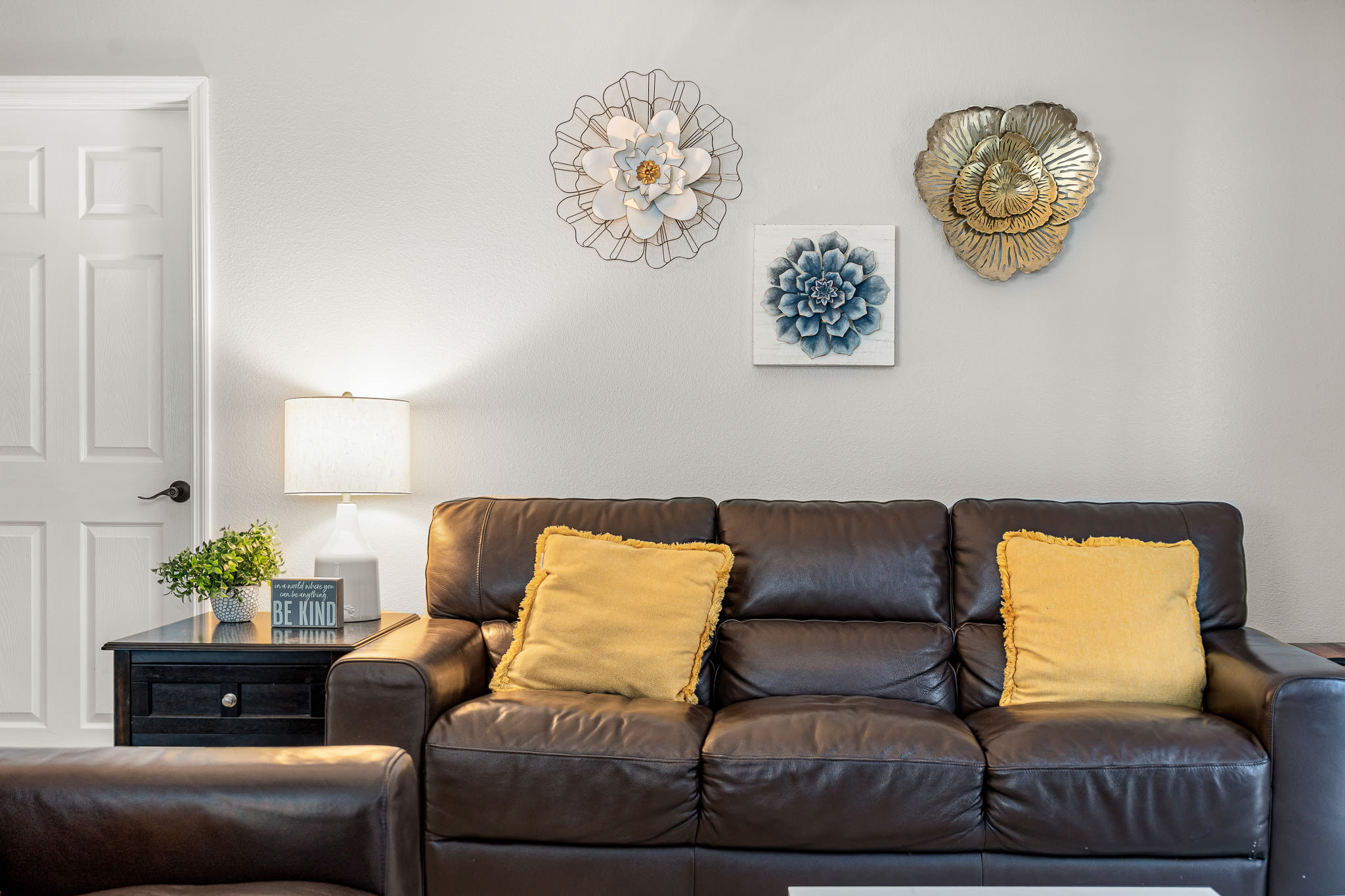 Welcoming living room w/ plush sofa, wall art, and warm neutral tones.