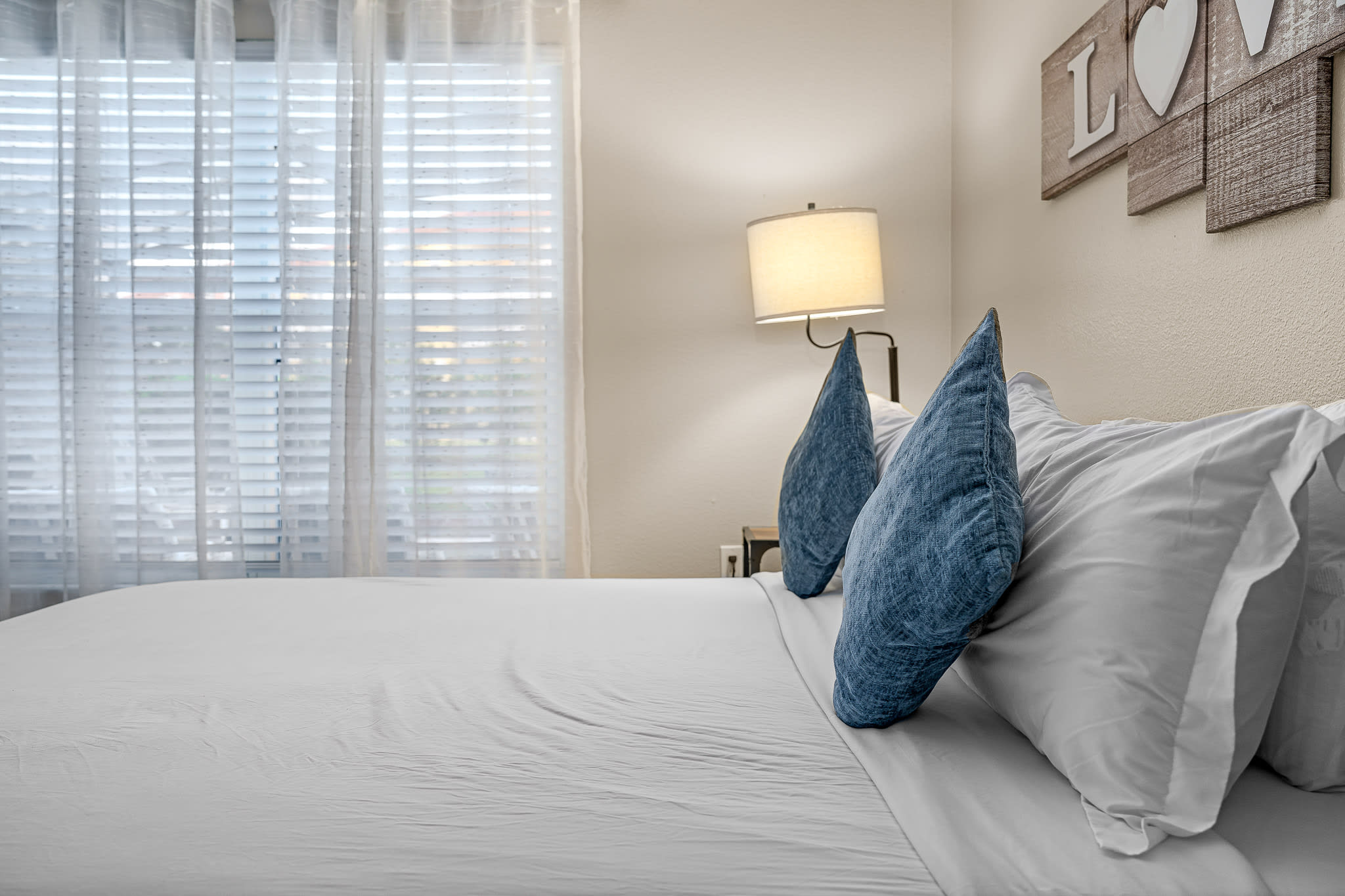 Calm sleeping space w/ neutral tones, cozy bedding, and a relaxed, airy feel.
