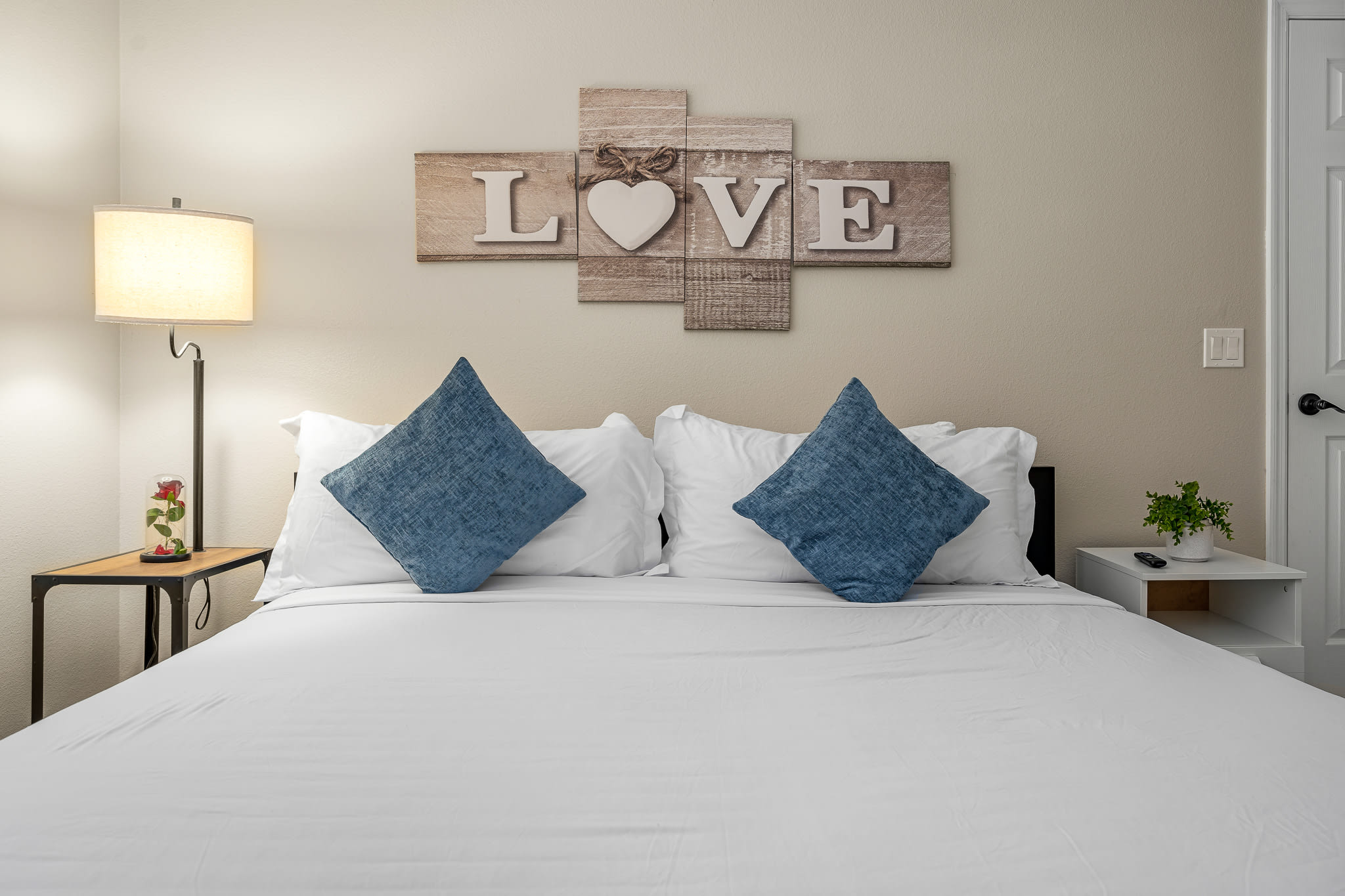 Inviting bedroom w/ plush bed, warm lighting, and a peaceful layout.