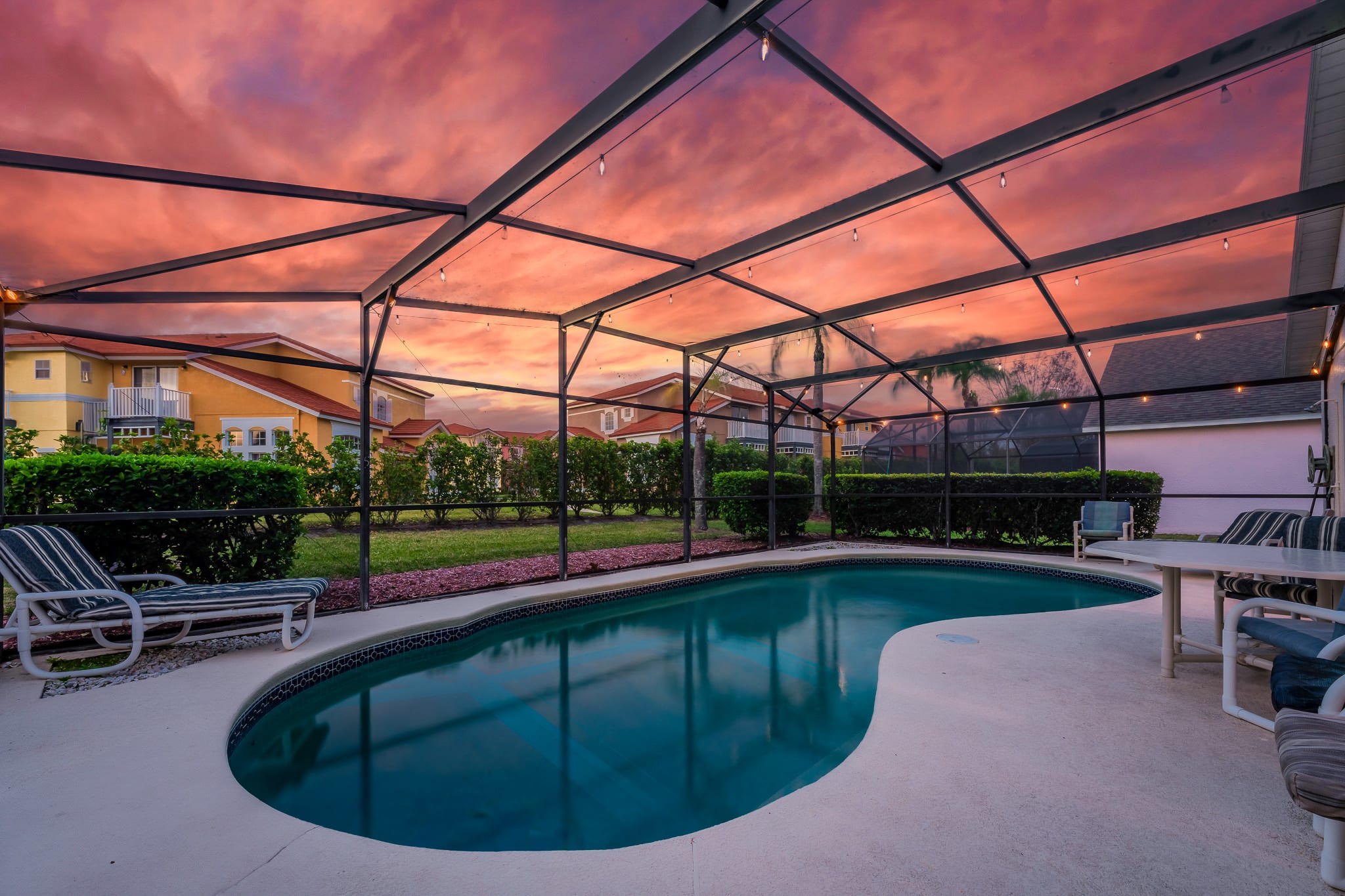 Screened pool enclosure glowing at sunset, perfect for evening swims.