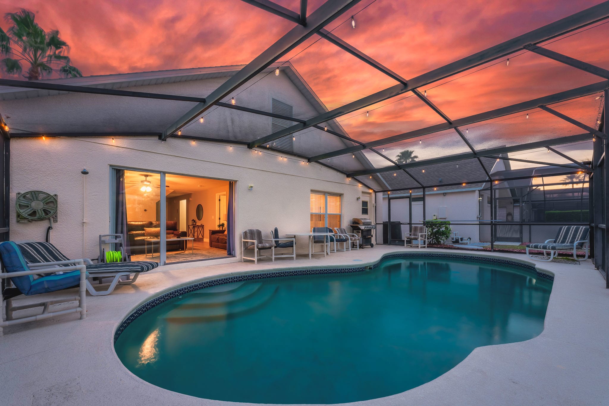 Spacious screened pool area w/ lounge seating and tranquil water views.