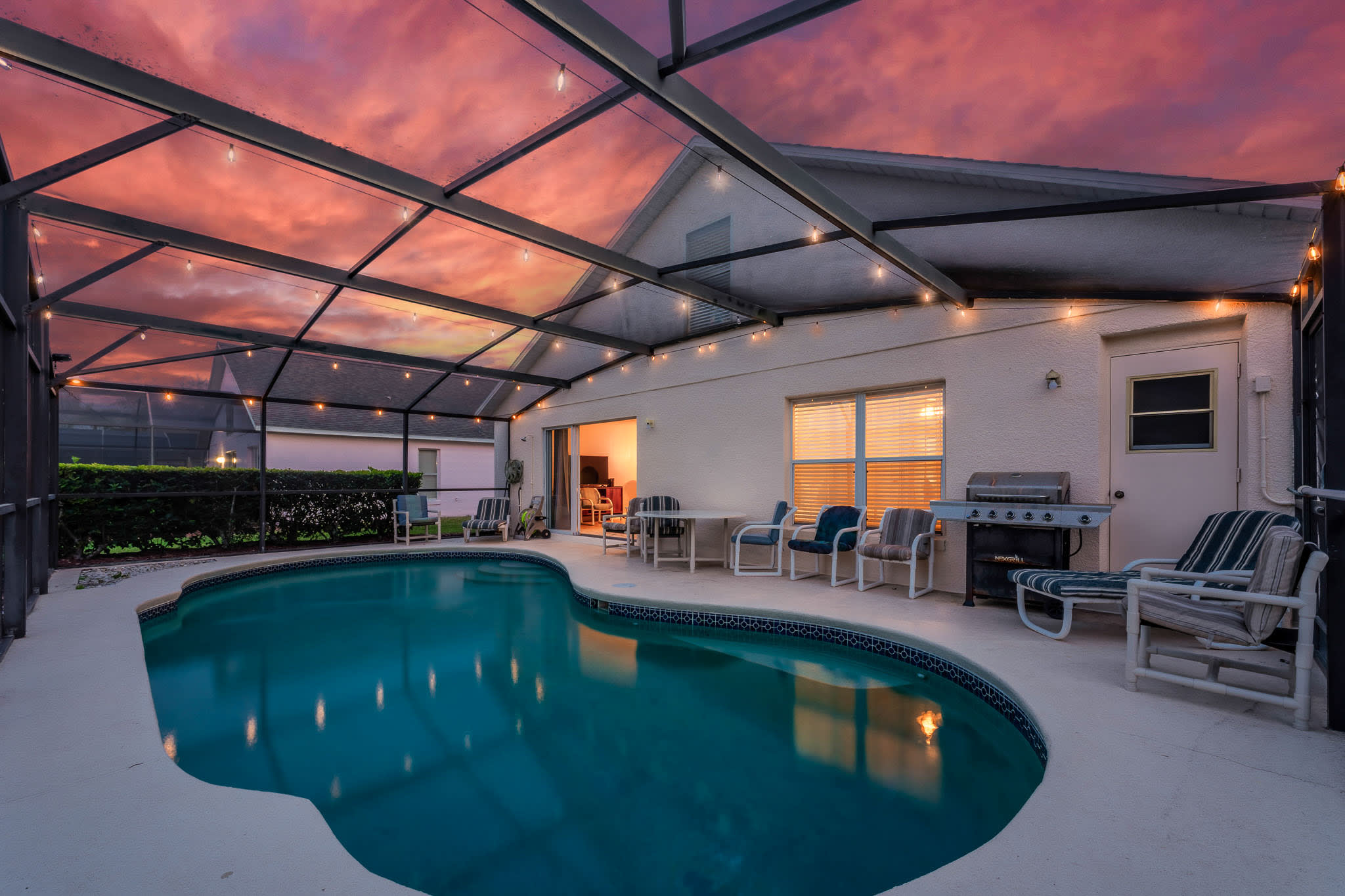 Screened-in pool glowing at sunset, ideal for relaxed evening swims.