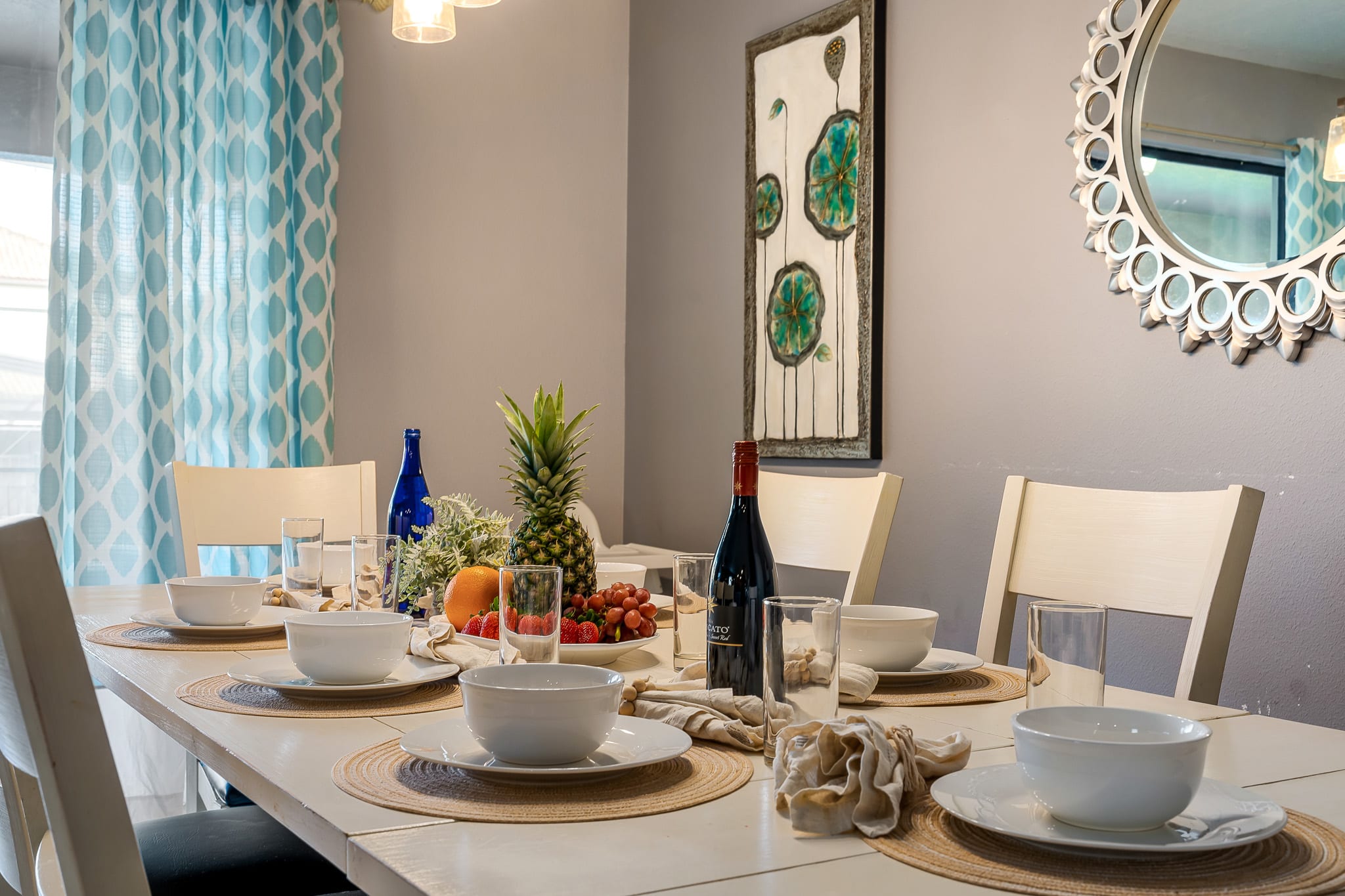 Sunlit dining area w/ modern table setting for shared meals.