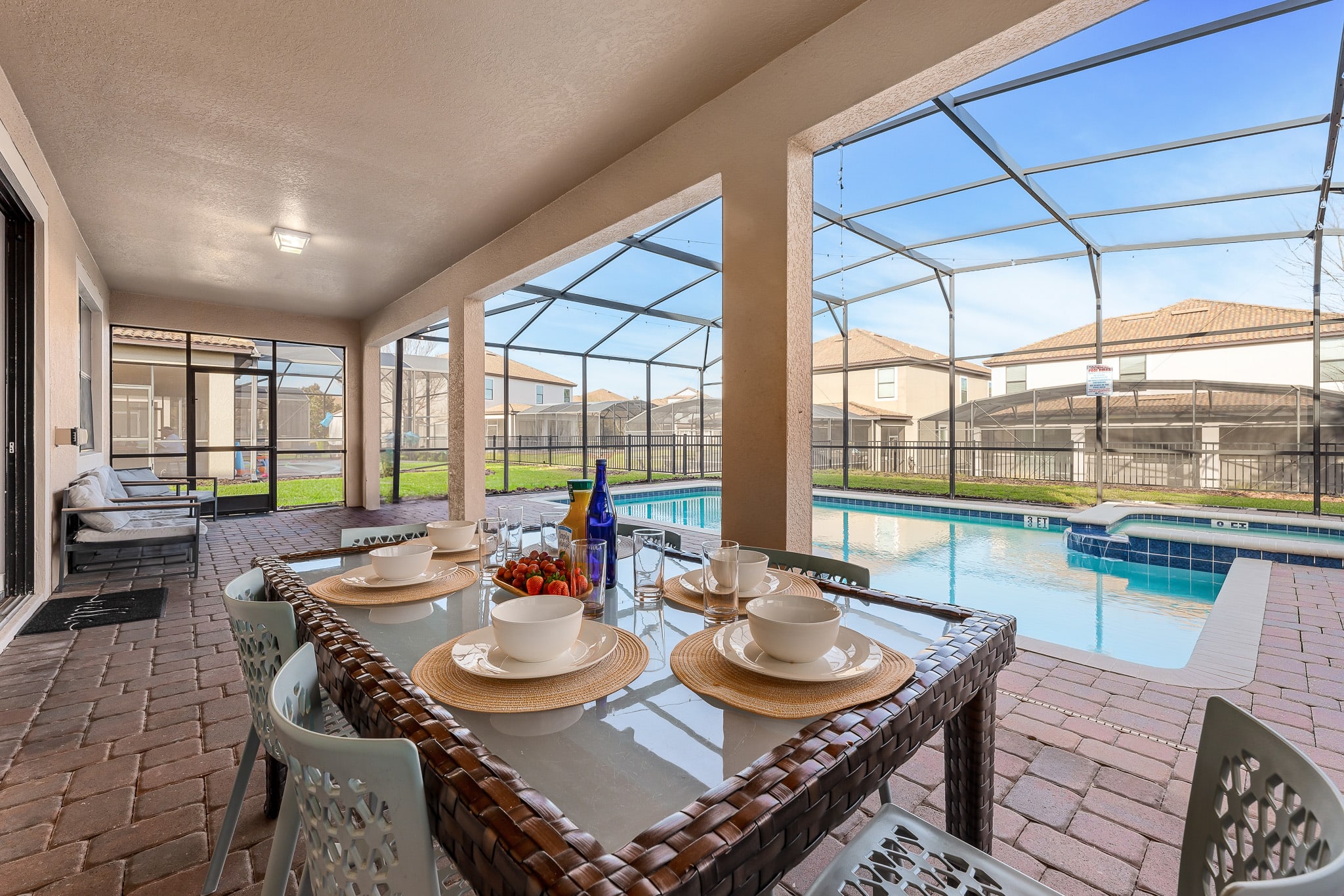 Covered outdoor dining area overlooking the screened pool, ideal for leisurely meals any time of day.