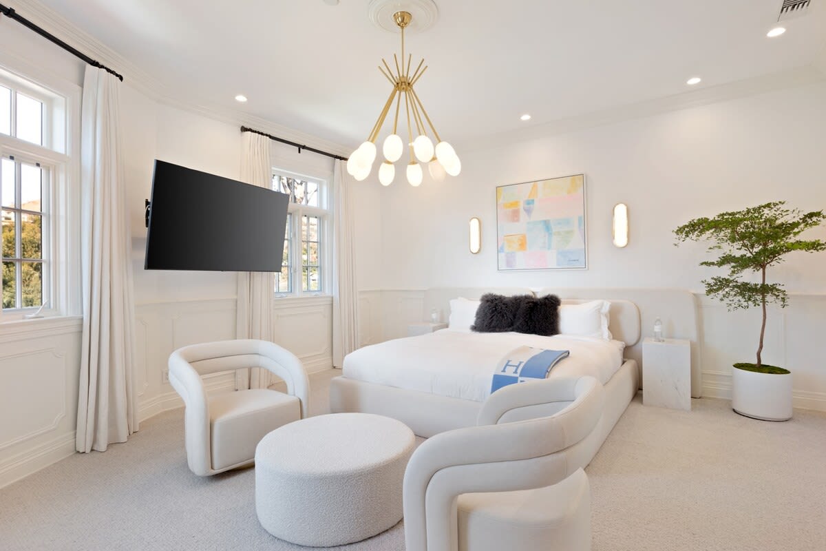 Featuring a cozy sitting area at the foot of the luxurious bed, a great spot to unwind