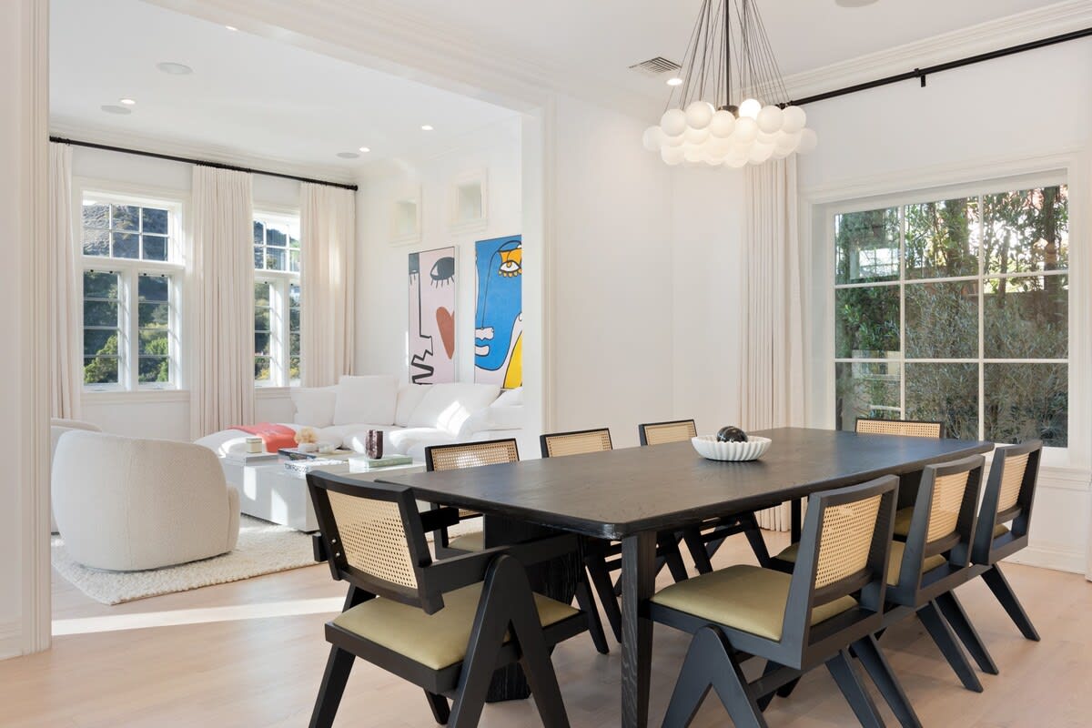 Space for 8 guests in the elegant dining area with natural light and a modern chandelier