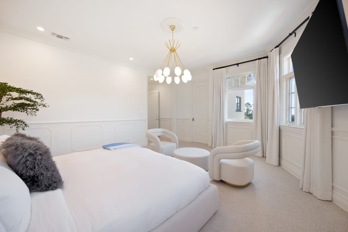 The luxurious bed faces a large smart TV