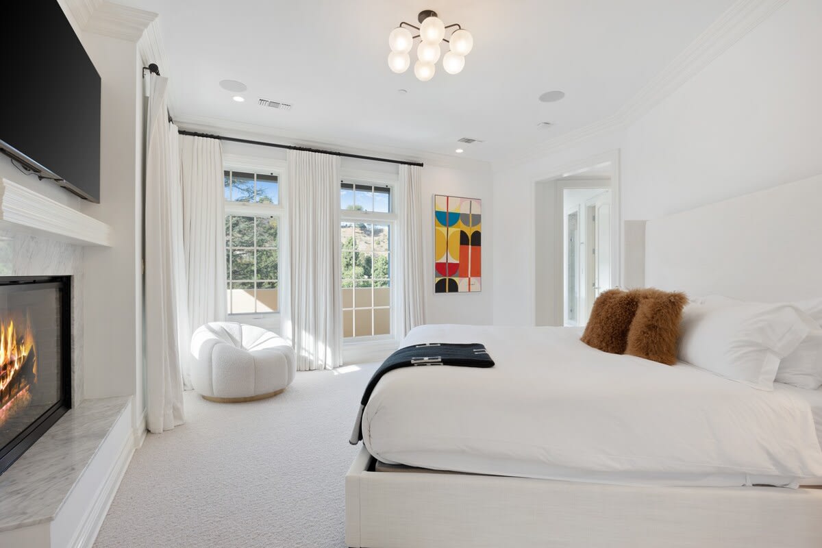 The luxurious bed faces a large smart TV