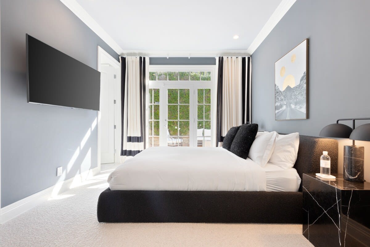 The luxurious bed faces a large smart TV