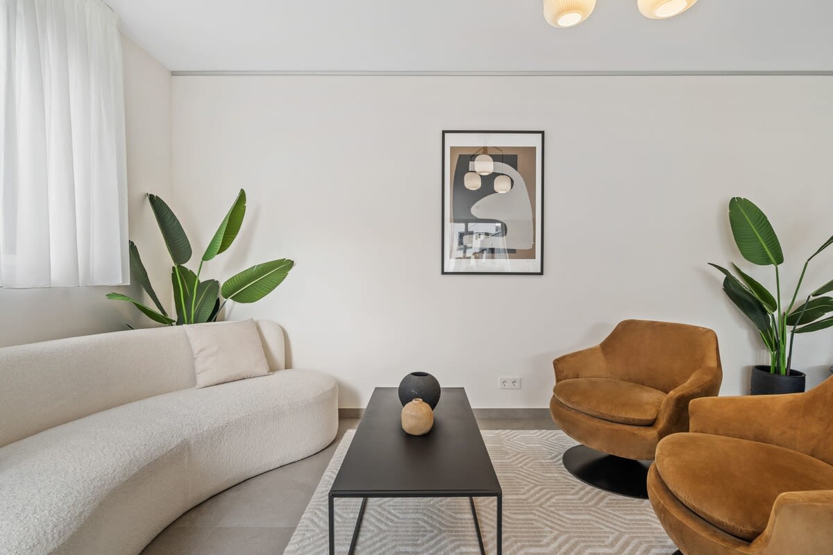 Relax in a cozy, chic living space with lush greenery and modern art accents.