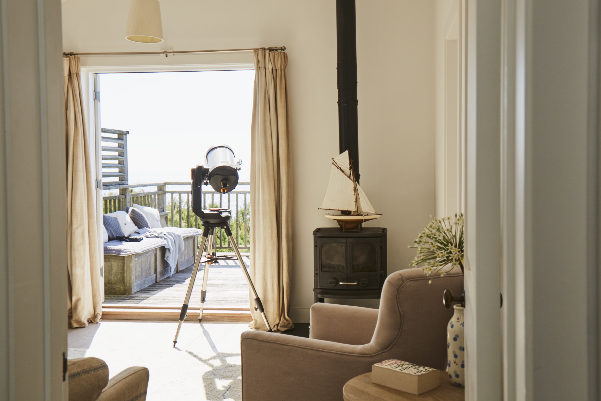 There is a relaxing living area just off the main bedroom. Depending on the time of year, light the log burner or open up the balcony doors to let the sea breeze in.