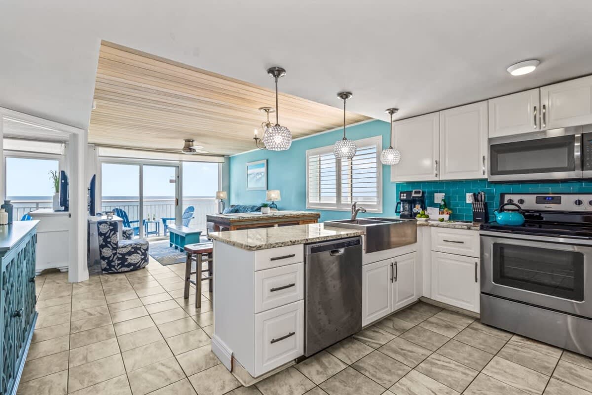 Cook, dine, and relax in this stunning open-concept space featuring a modern kitchen with granite countertops, stainless steel appliances, and vibrant coastal accents. The dining area flows seamlessly to the living room, all with gorgeous ocean views