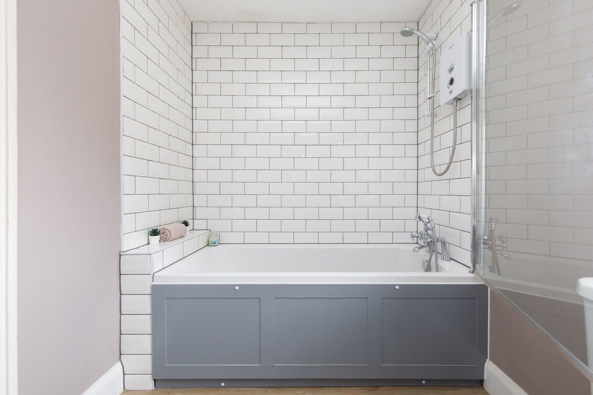 Clean full size bath with shower over