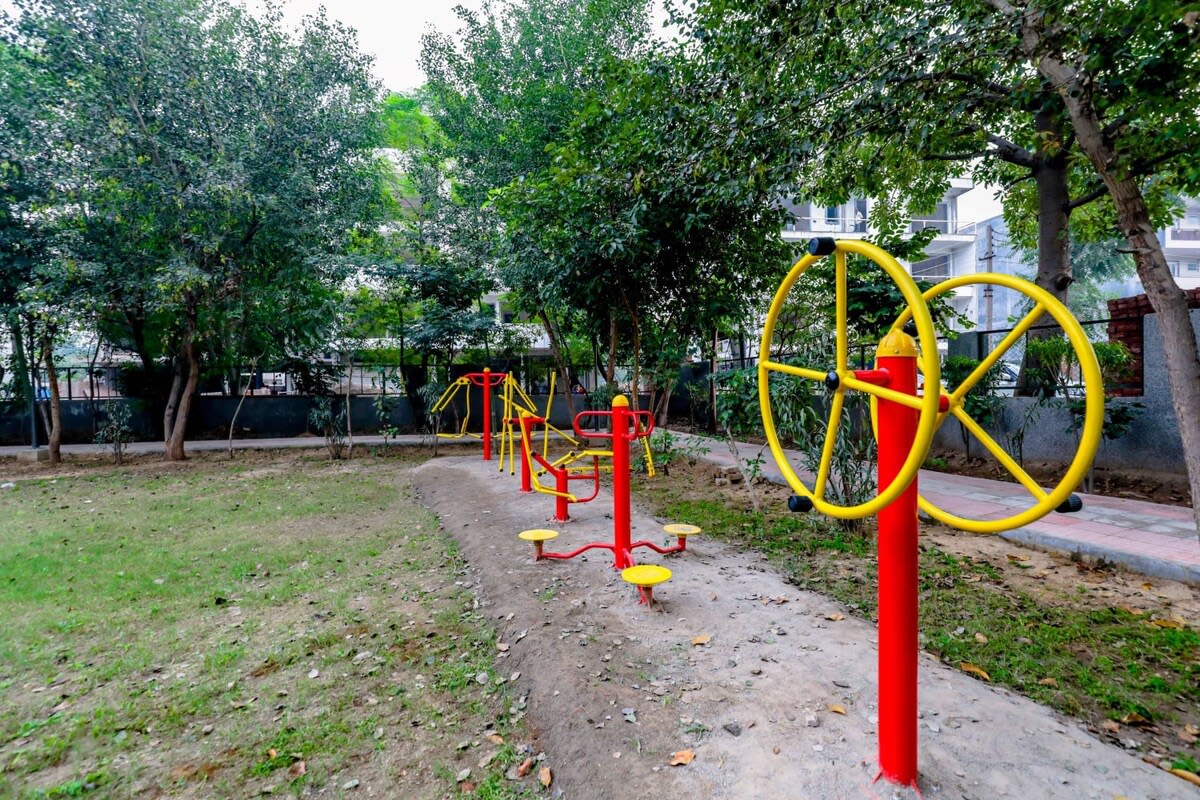 A vibrant park scene featuring children enjoying rides and games, with colorful play equipment and joyful laughter filling the air