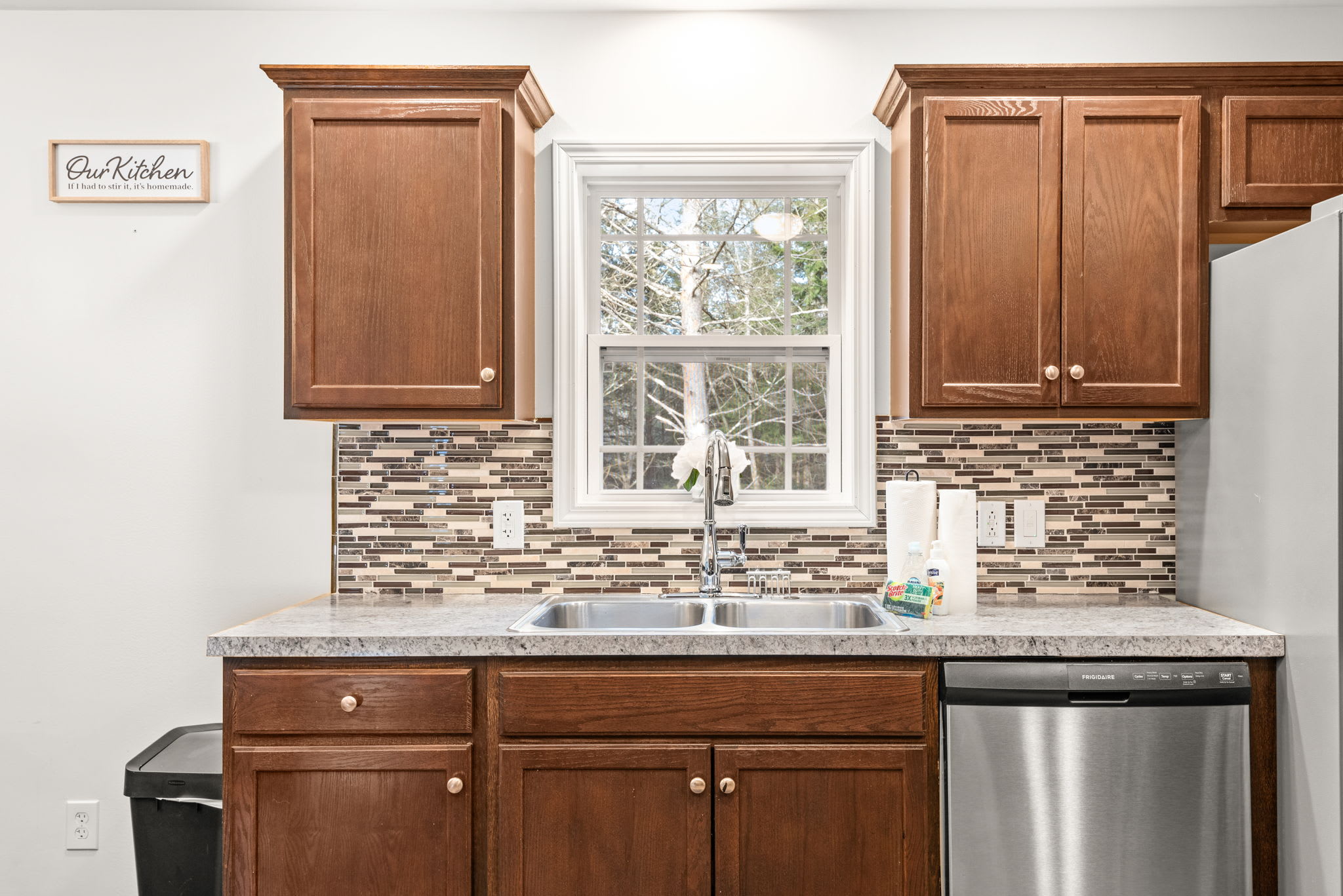 This bright kitchen corner features a window over the sink, bringing in natural light and a glimpse of the peaceful outdoors as you prep or clean up.