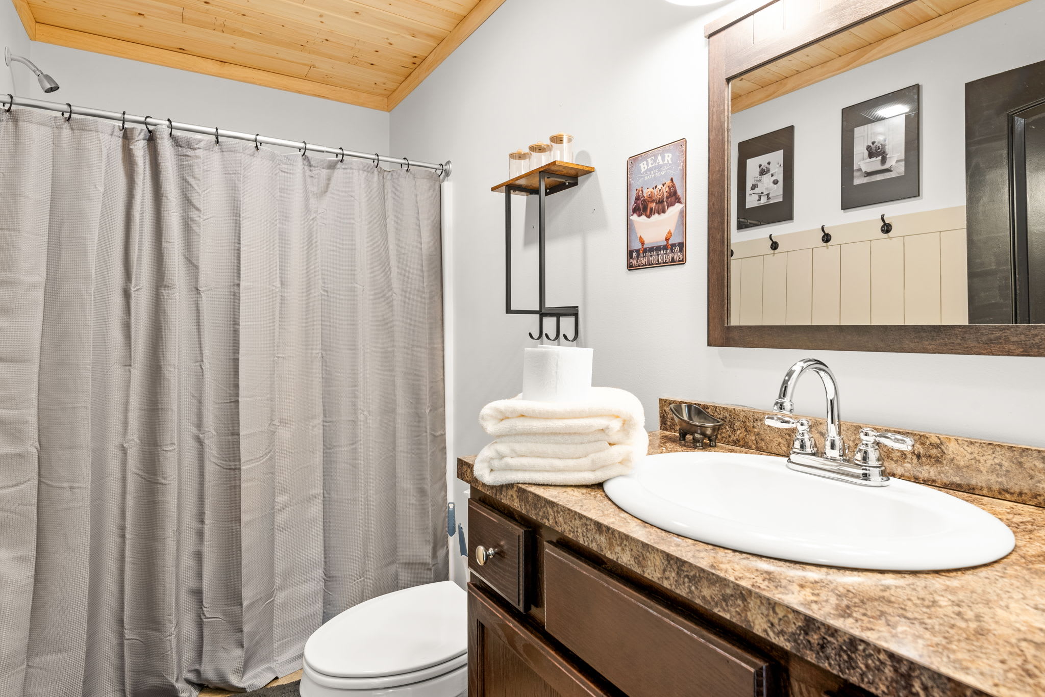 With rich wood cabinetry, warm-toned counters, and soft lighting, this bathroom offers a comforting, cabin-inspired space to refresh and unwind.