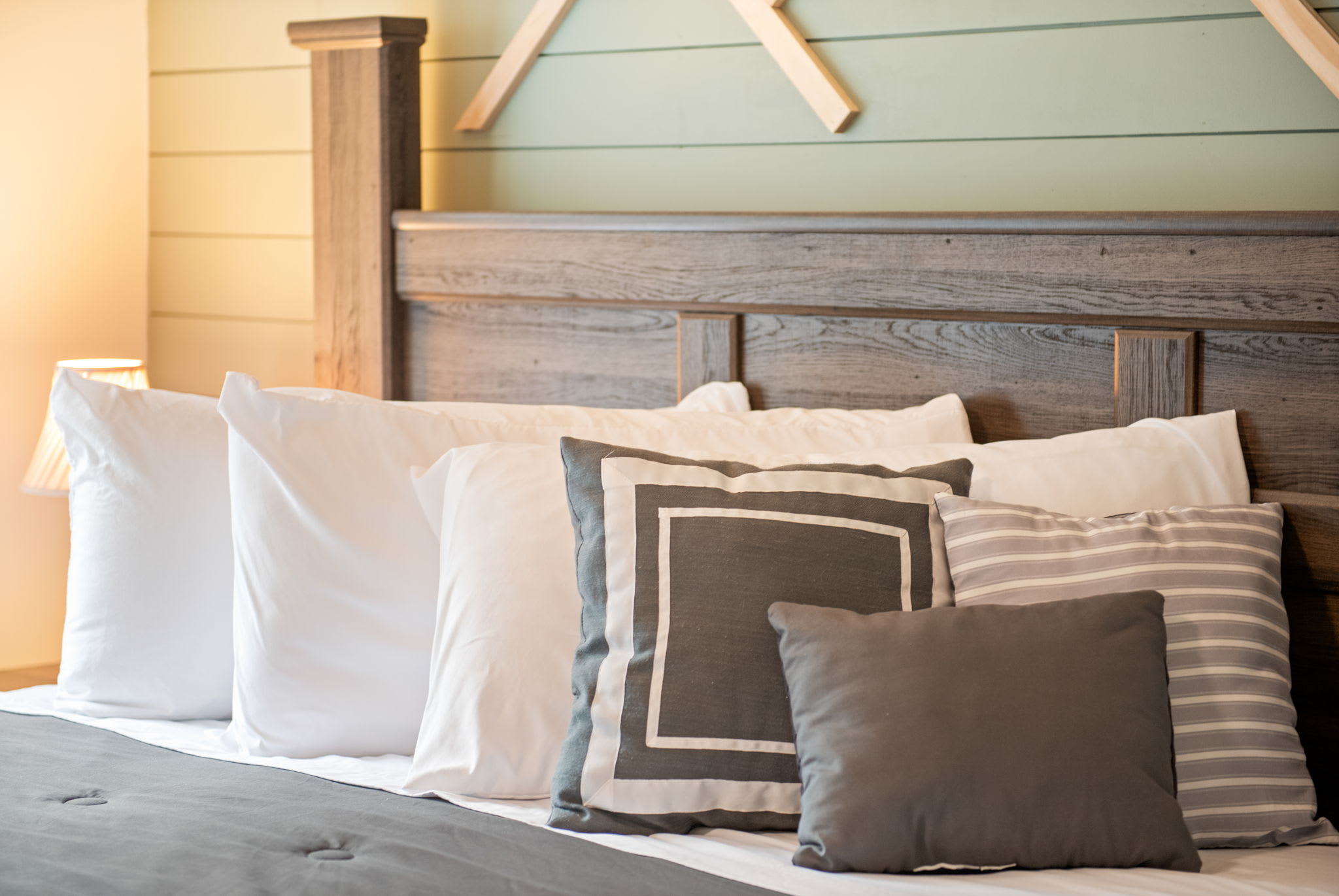 The layered bedding, soft lighting, and mountain-inspired wall décor create a space that’s both calming and full of character.