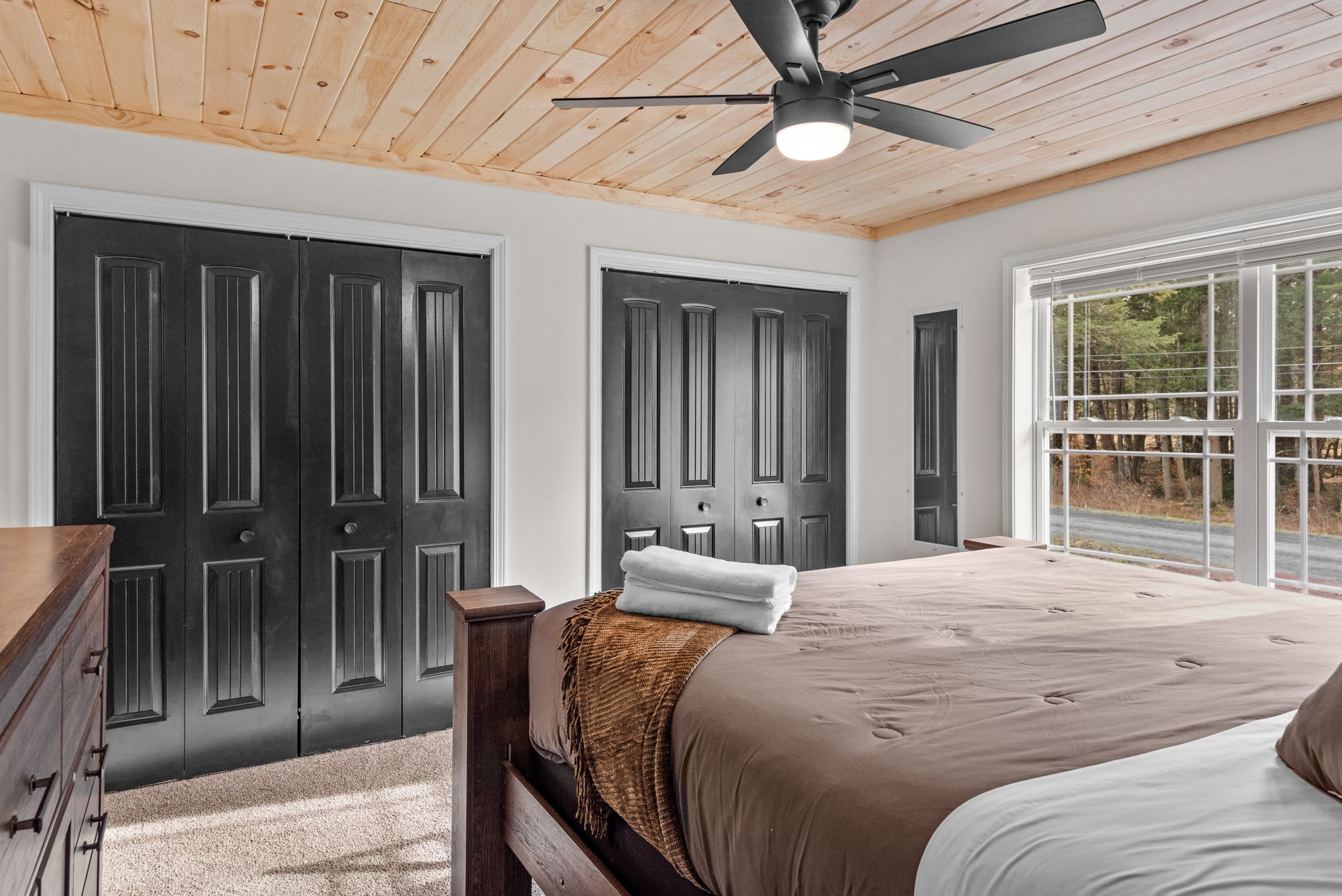 Natural Light & Plenty of Space
With large windows, sleek black closet doors, and ample room to move around, this master bedroom is equal parts charming and functional.
