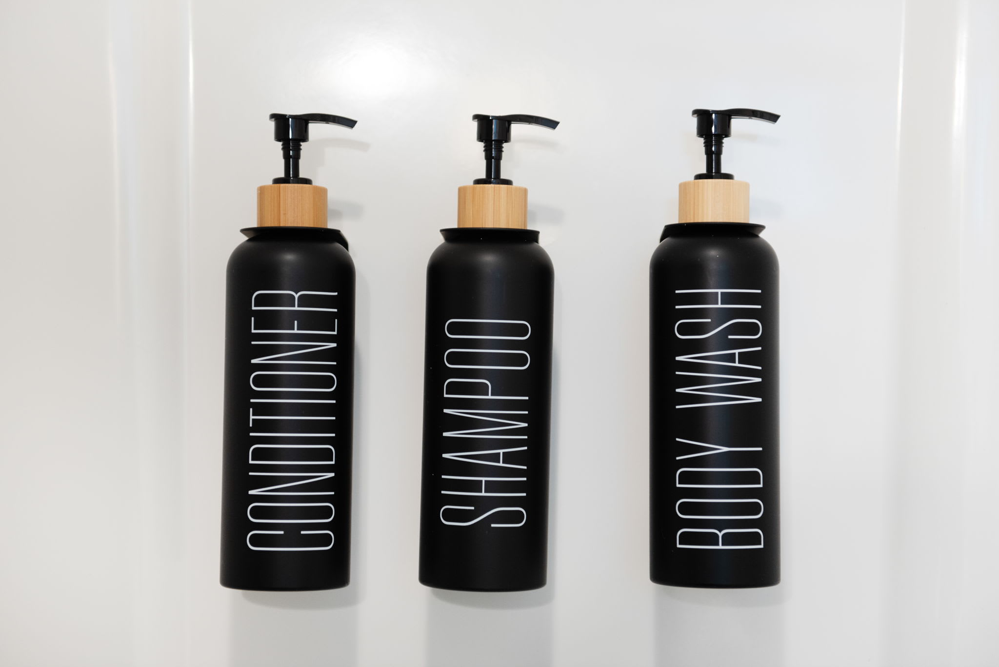 Refillable matte black bottles with bold, minimalist labeling bring a touch of spa-like style and sustainability to your shower experience.