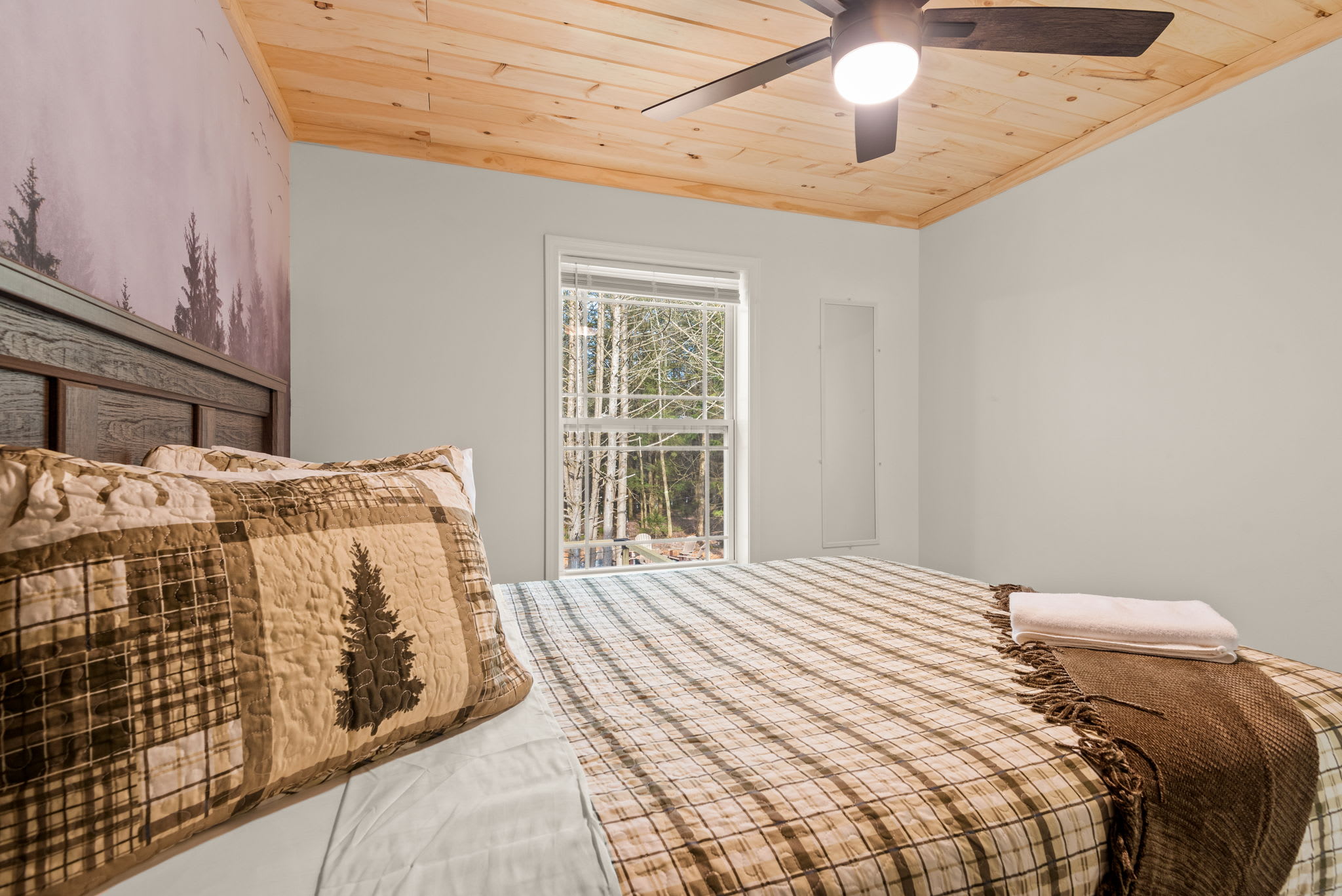 The soft natural light, cozy throw, and nature-themed pillows make this room feel like a peaceful little lodge tucked in the trees.