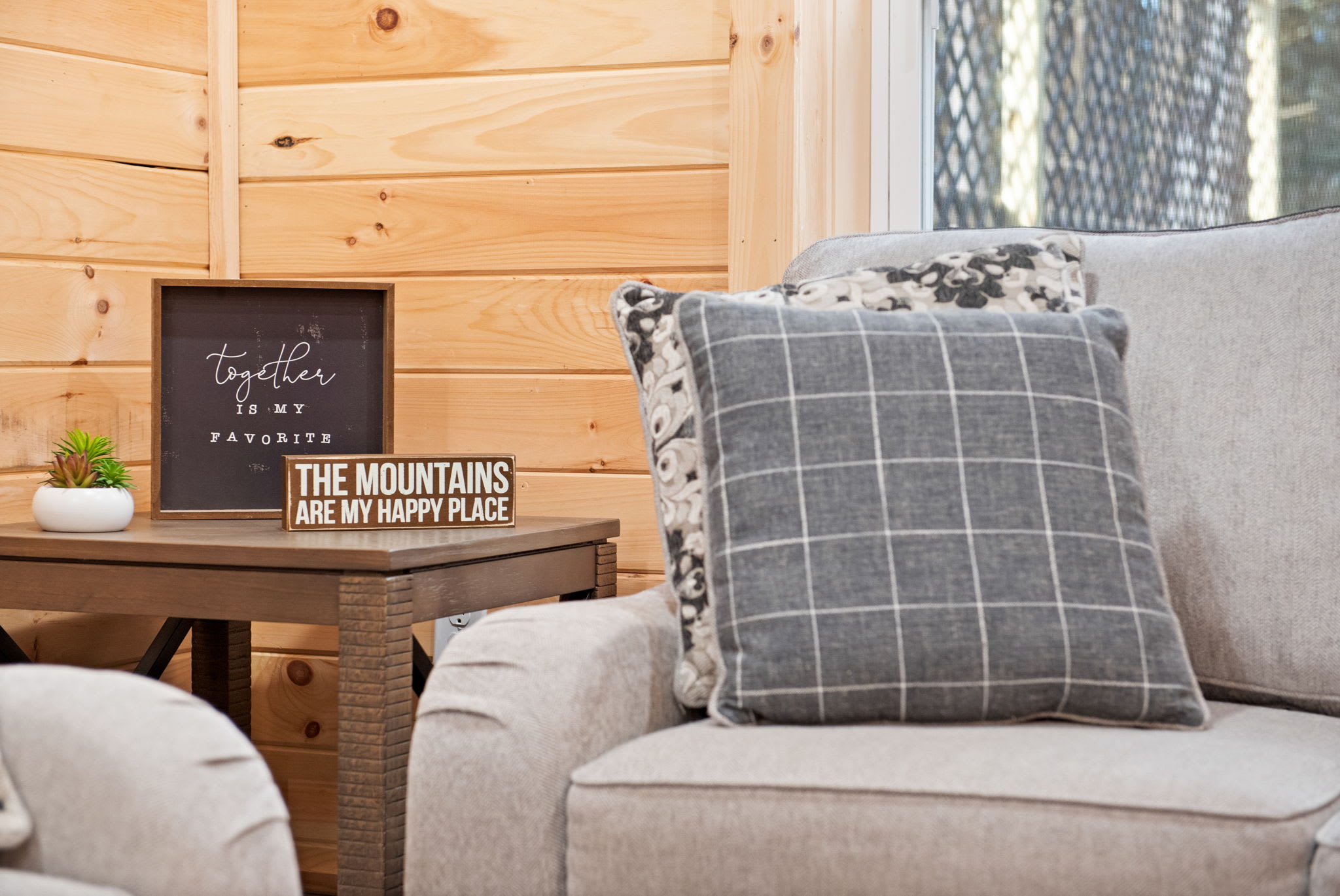 Cozy up with thoughtful decor like this mountain-inspired sign and plush cushions because every detail is designed to feel like home.