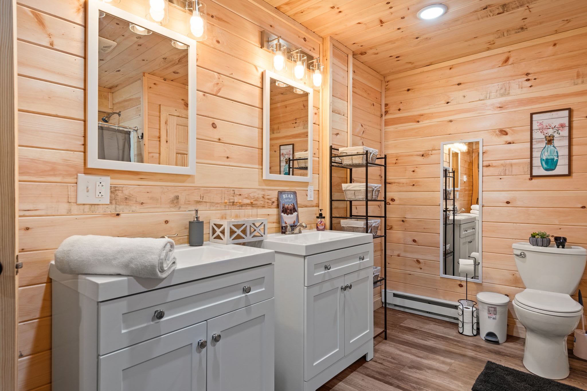Cabin-Style Bathroom with Double Vanity
A roomy full bathroom with knotty pine walls, modern lighting, and a spacious double-sink vanity perfect for groups or families sharing the space.