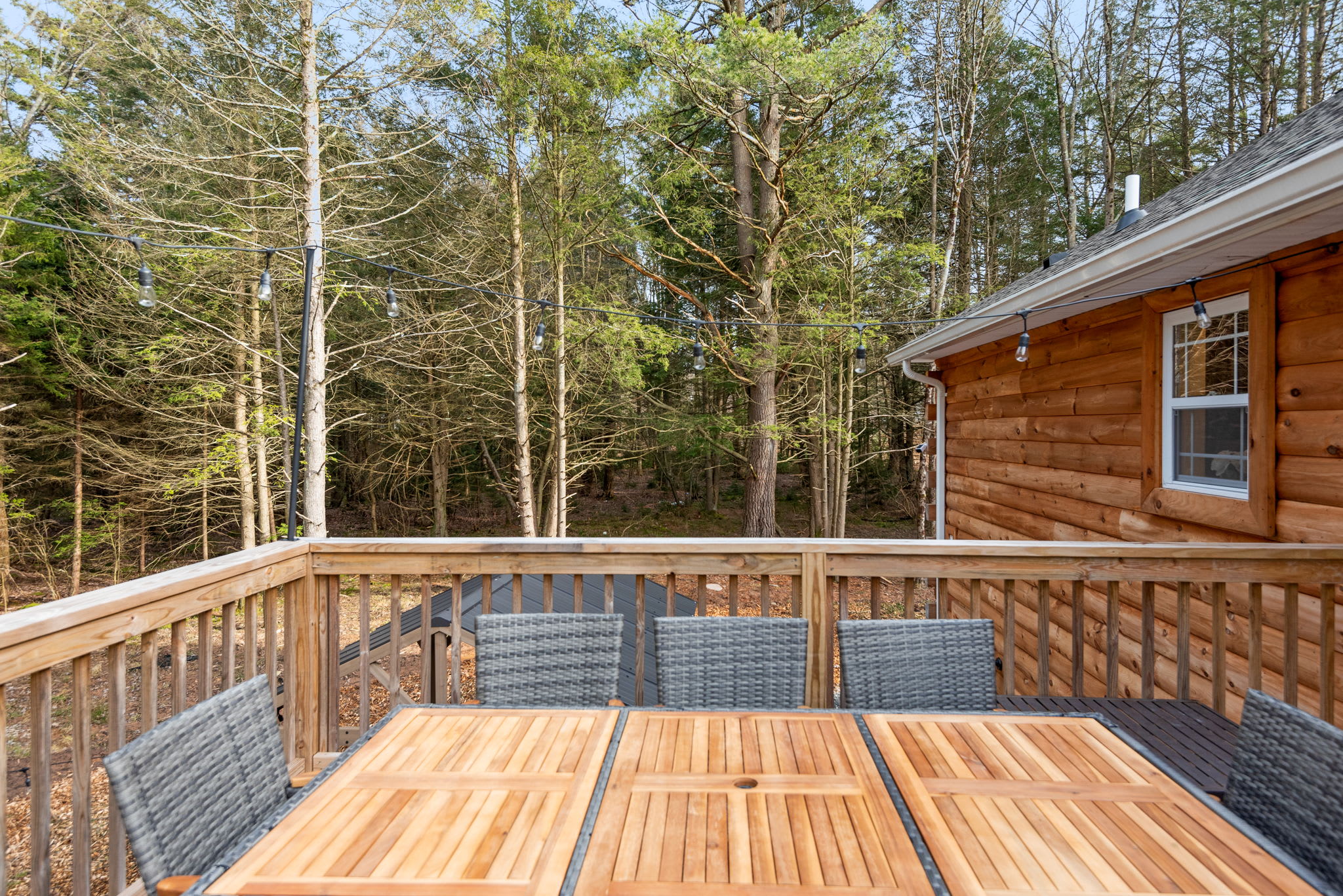 Surrounded by tall trees and fresh mountain air, this outdoor table setup is perfect for everything from sunny breakfasts to starlit dinners.