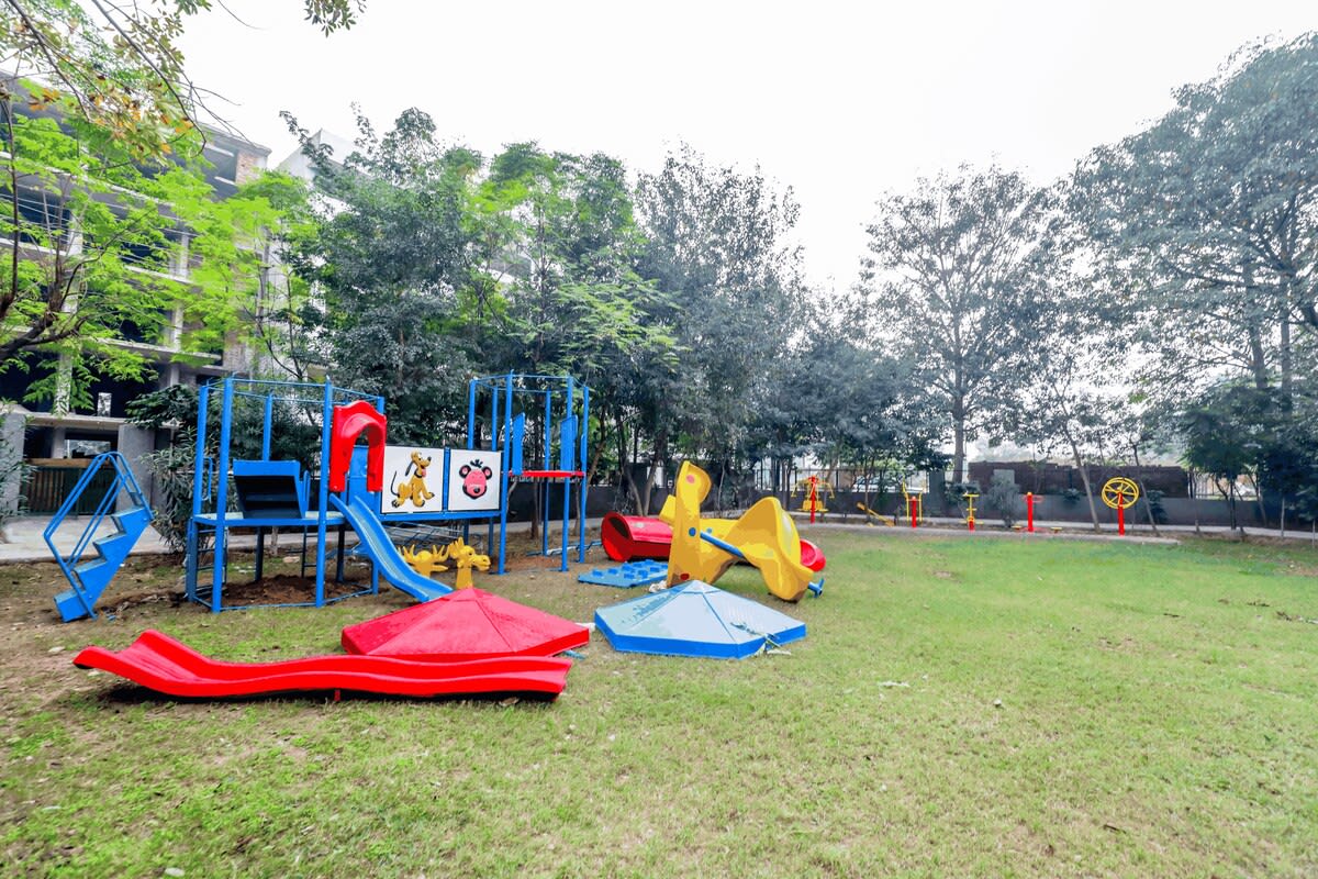 A vibrant park scene featuring children enjoying rides and games, with colorful play equipment and joyful laughter filling the air