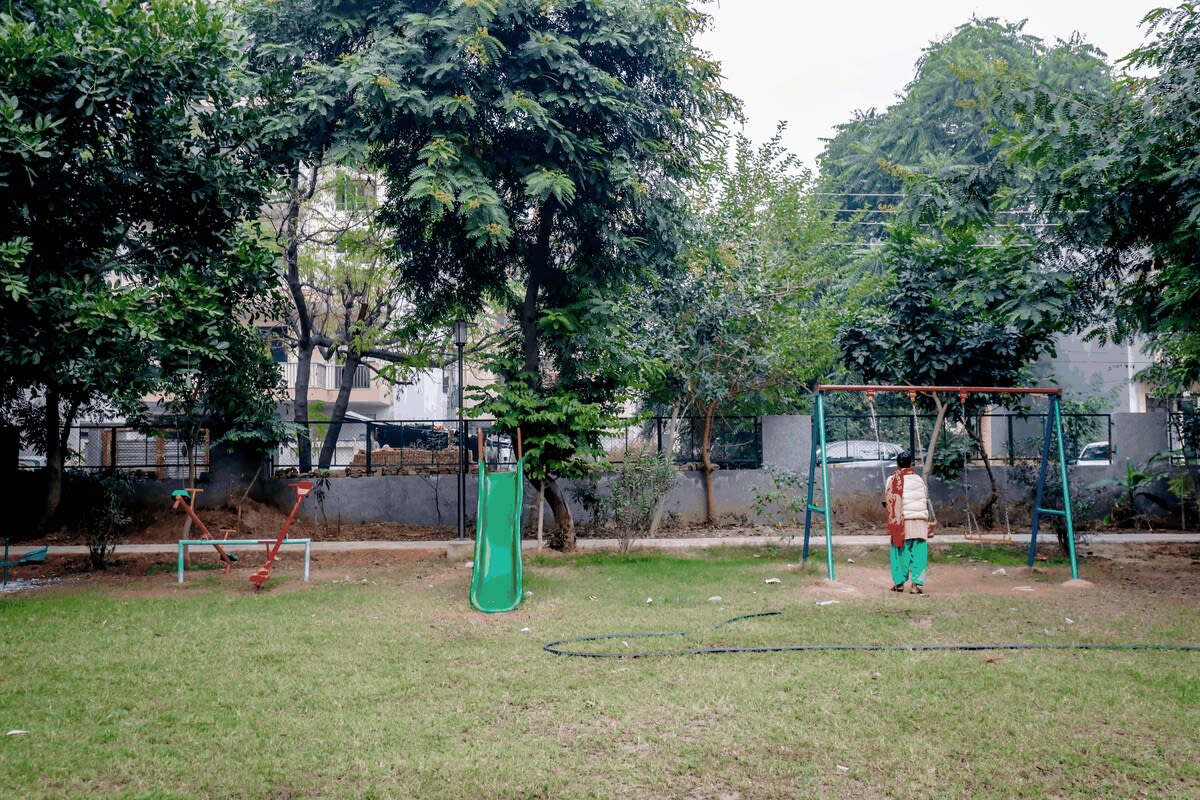 A vibrant park scene featuring children enjoying rides and games, with colorful play equipment and joyful laughter filling the air