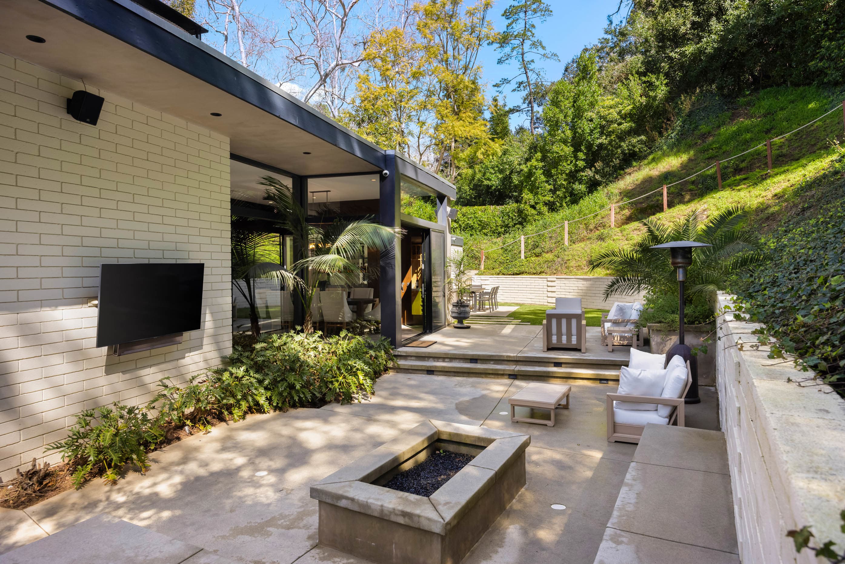 Immerse yourself in the ambiance of the outdoor seating area, complete with a captivating fire pit and an outdoor Smart TV.