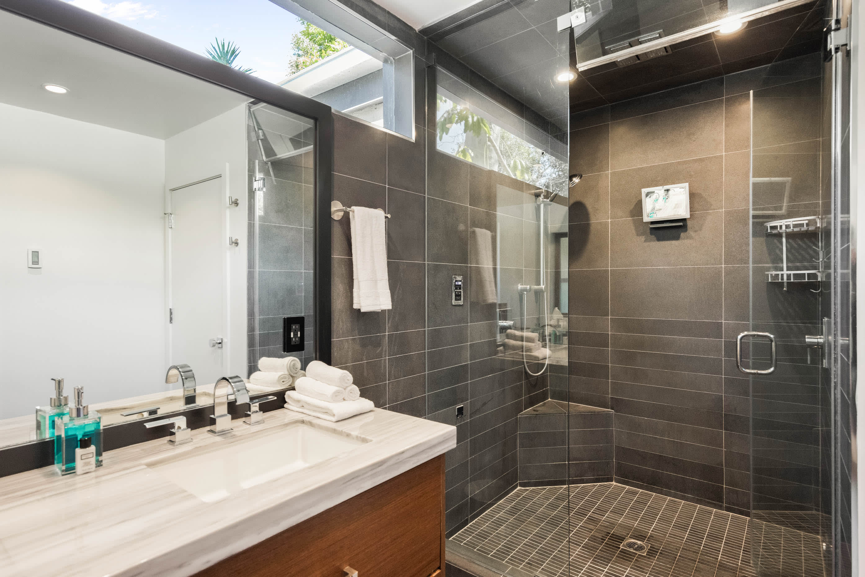 Step into the expansive walk-in glass shower, offering ample space and modern elegance.