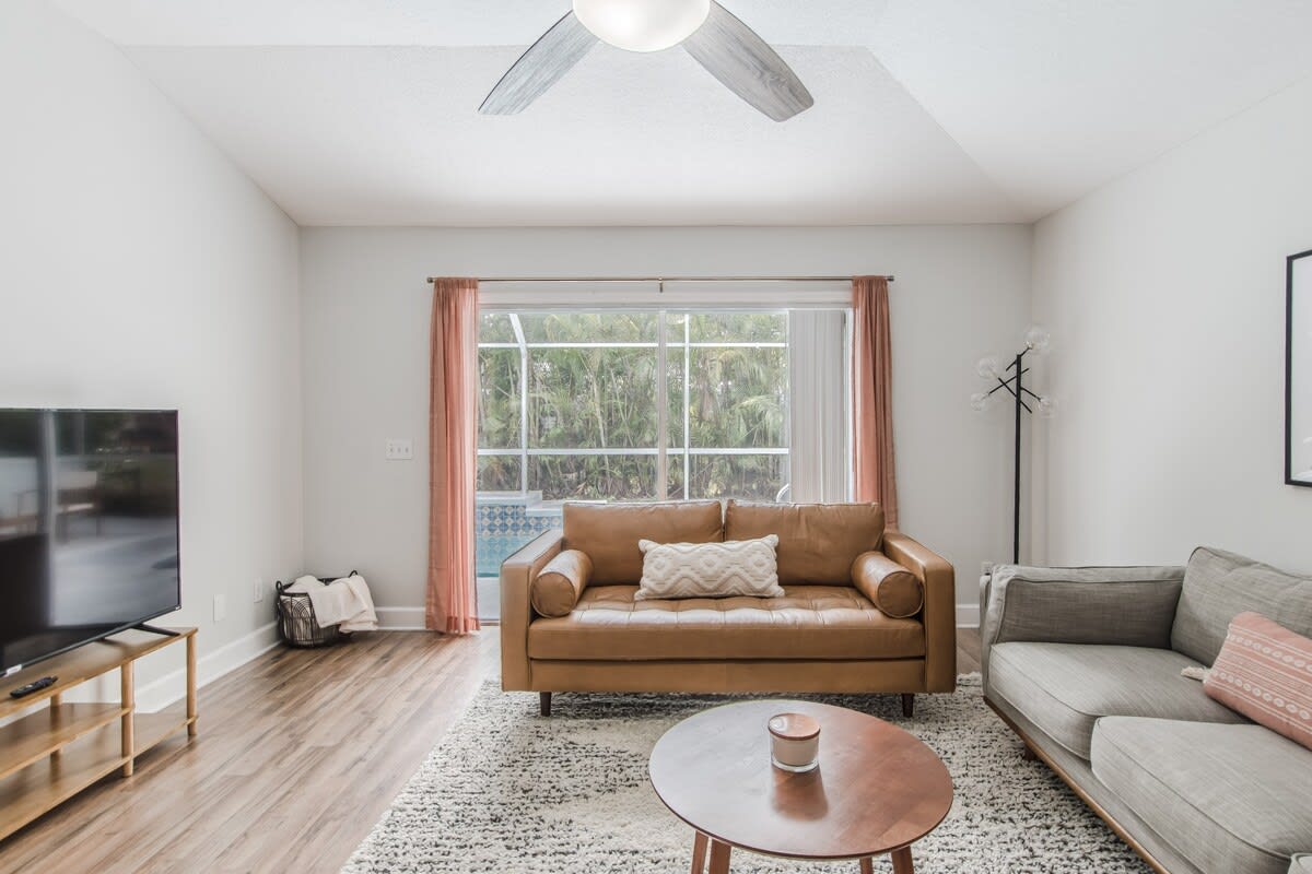 Living room with 65" TV and sliding doors that open to the backyard pool area.
