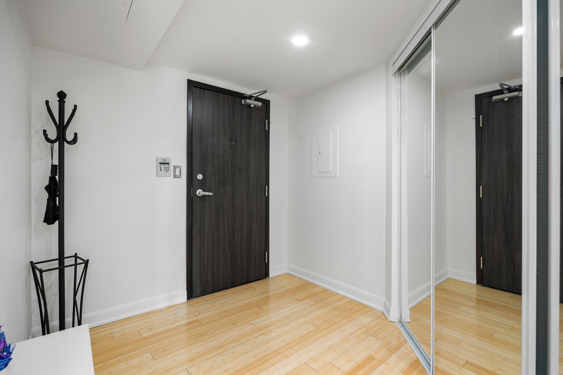 Sleek Entryway Featuring A Coat Stand And Minimalist Decor
