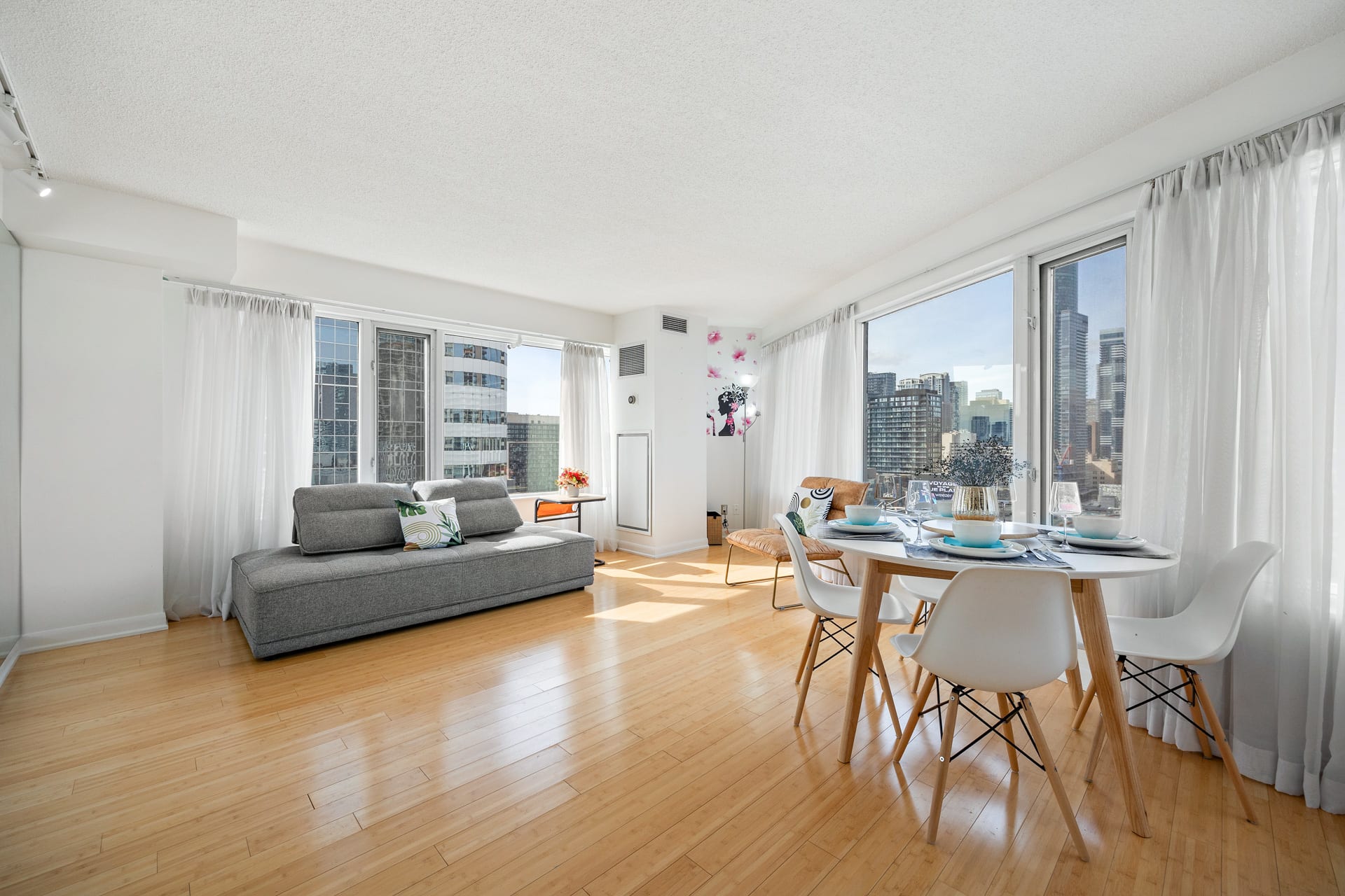 Open-concept living and dining area surrounded by large glass windows