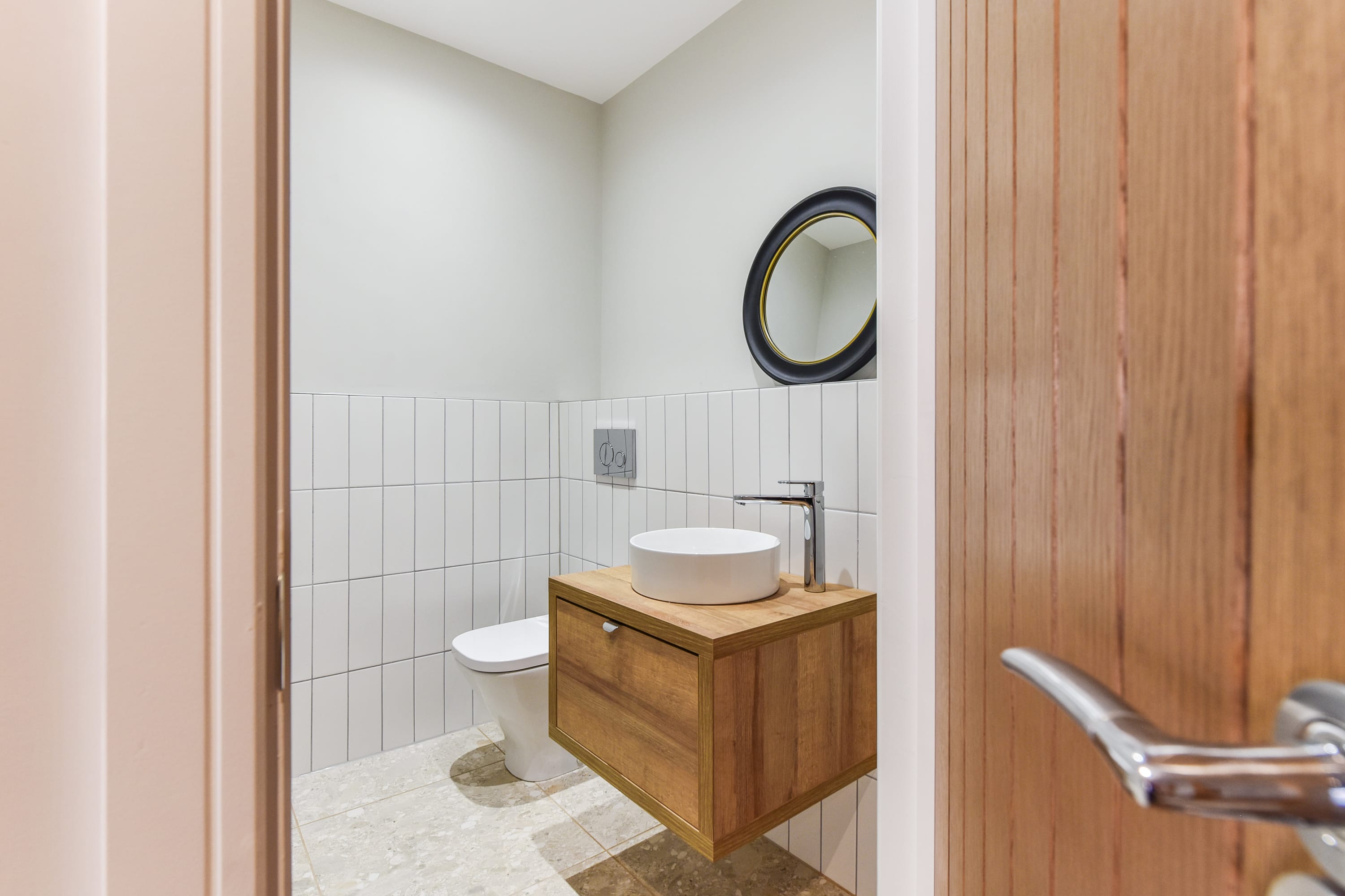 An ensuite shower room with sink, overhead mirror & WC.