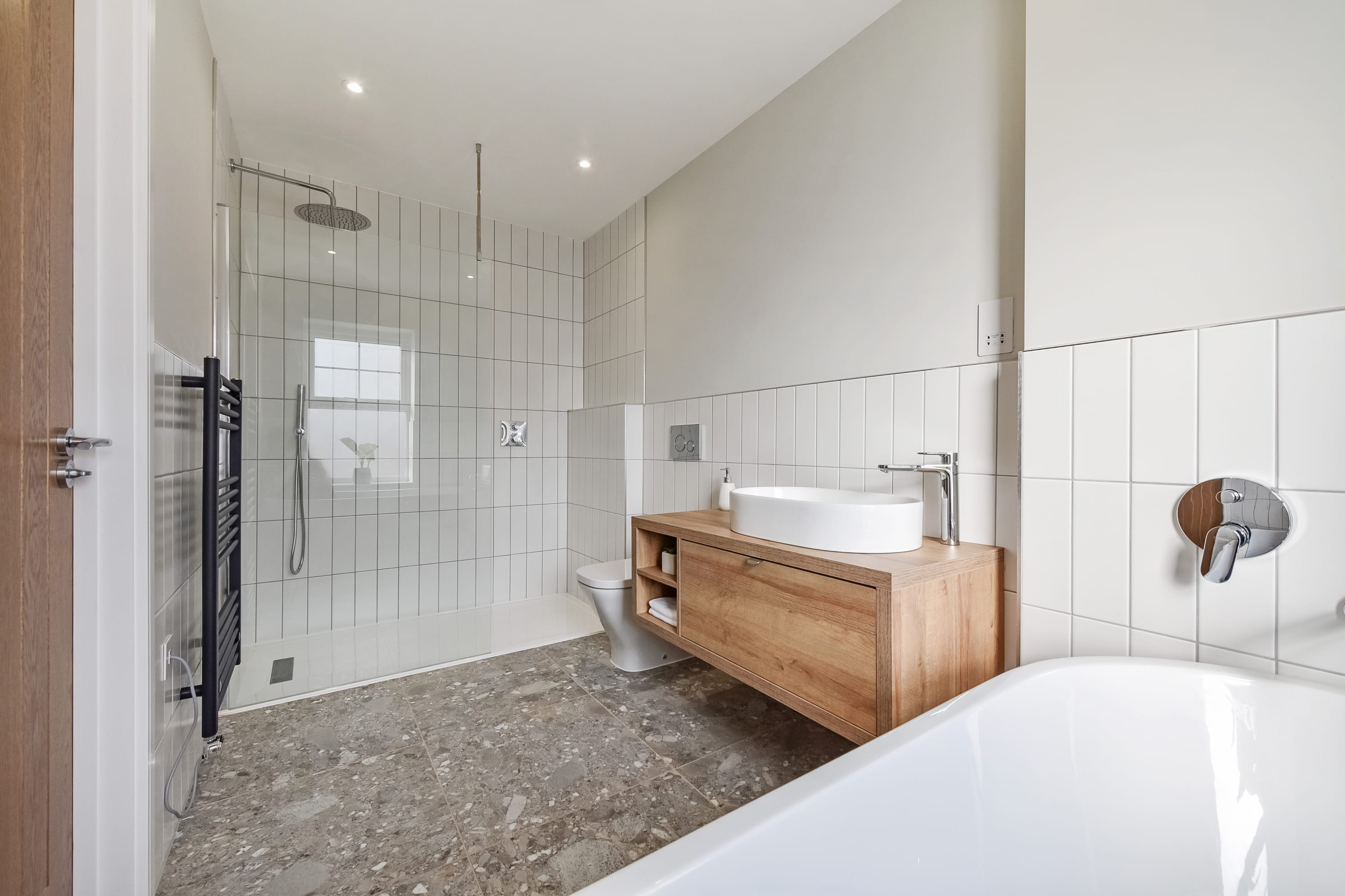 Ensuite bathroom with bath, overhead walk in shower, sink and WC.