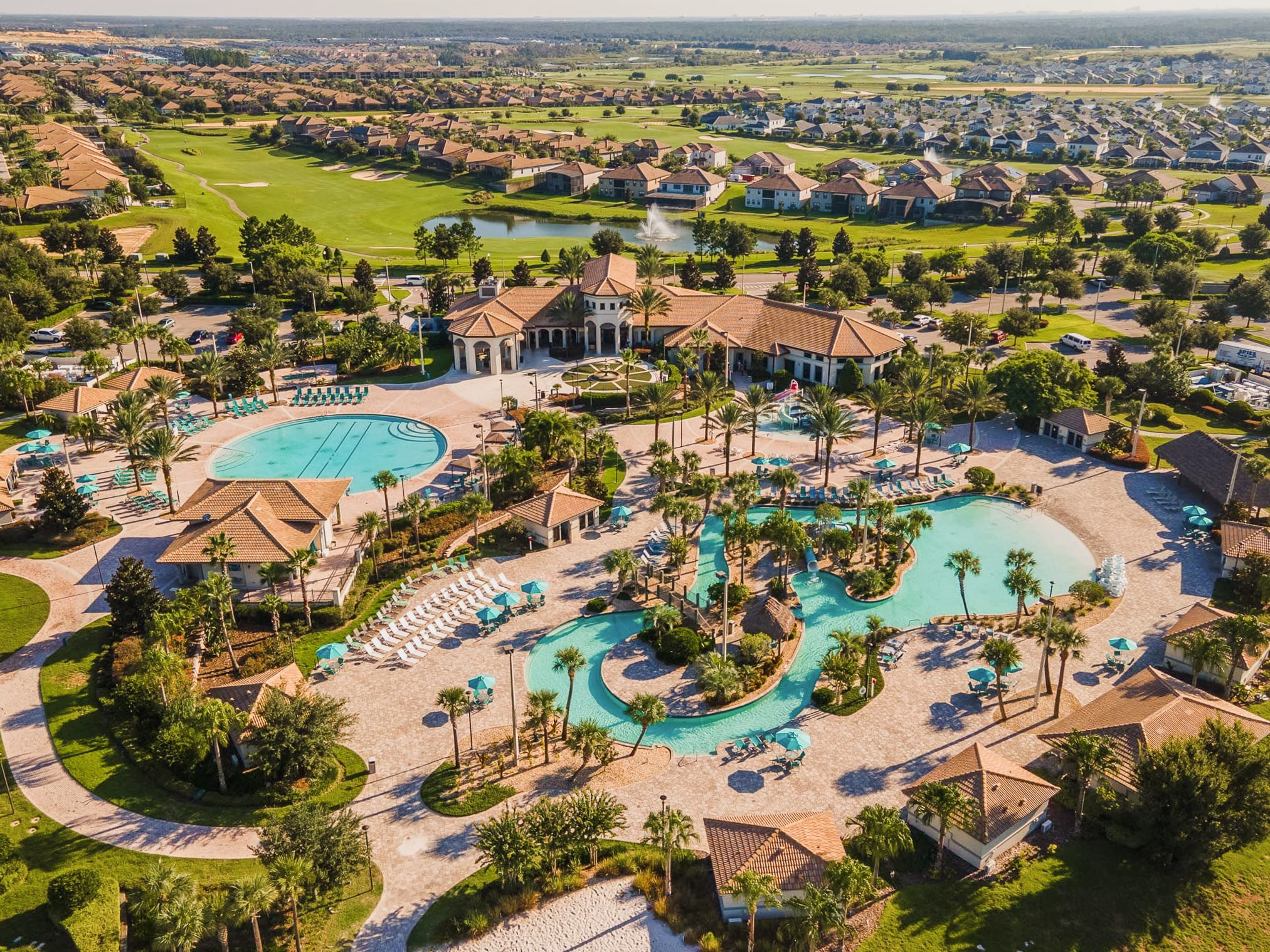 Aerial view showcasing a large pool area surrounded by lush landscaping.