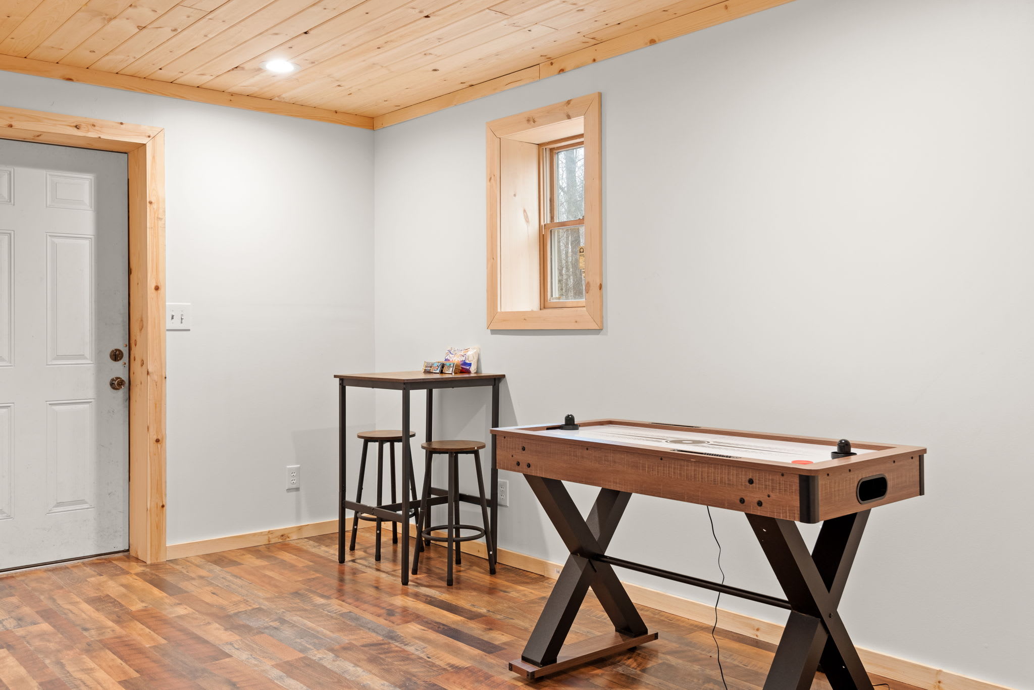 A sleek shuffleboard table and a cozy high-top table create the perfect setting for friendly competition and relaxation.