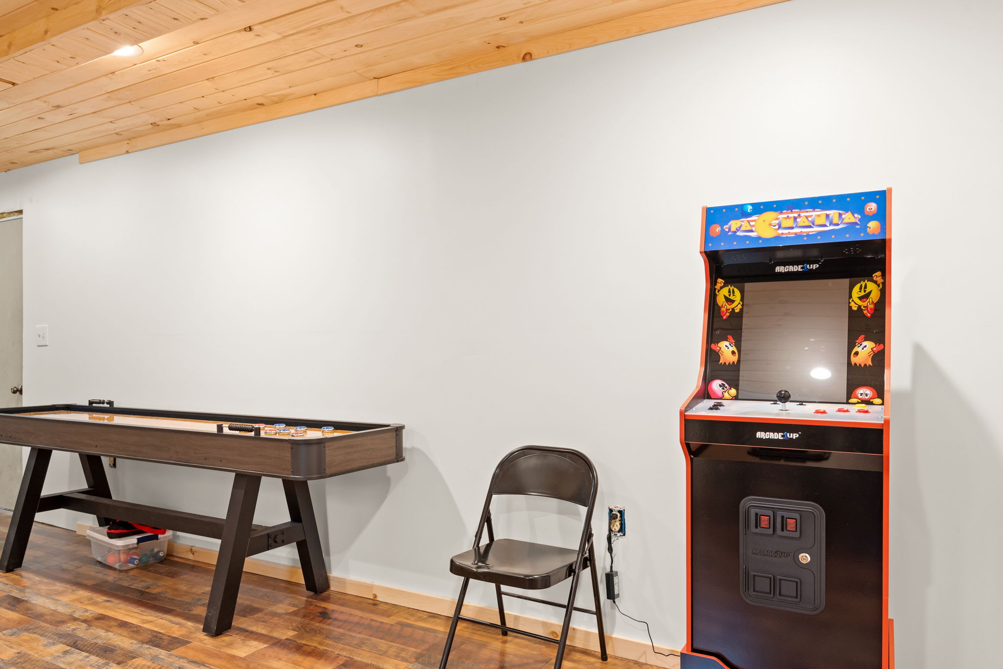 A mix of vintage charm and modern fun with a shuffleboard table and a classic arcade machine for hours of entertainment.