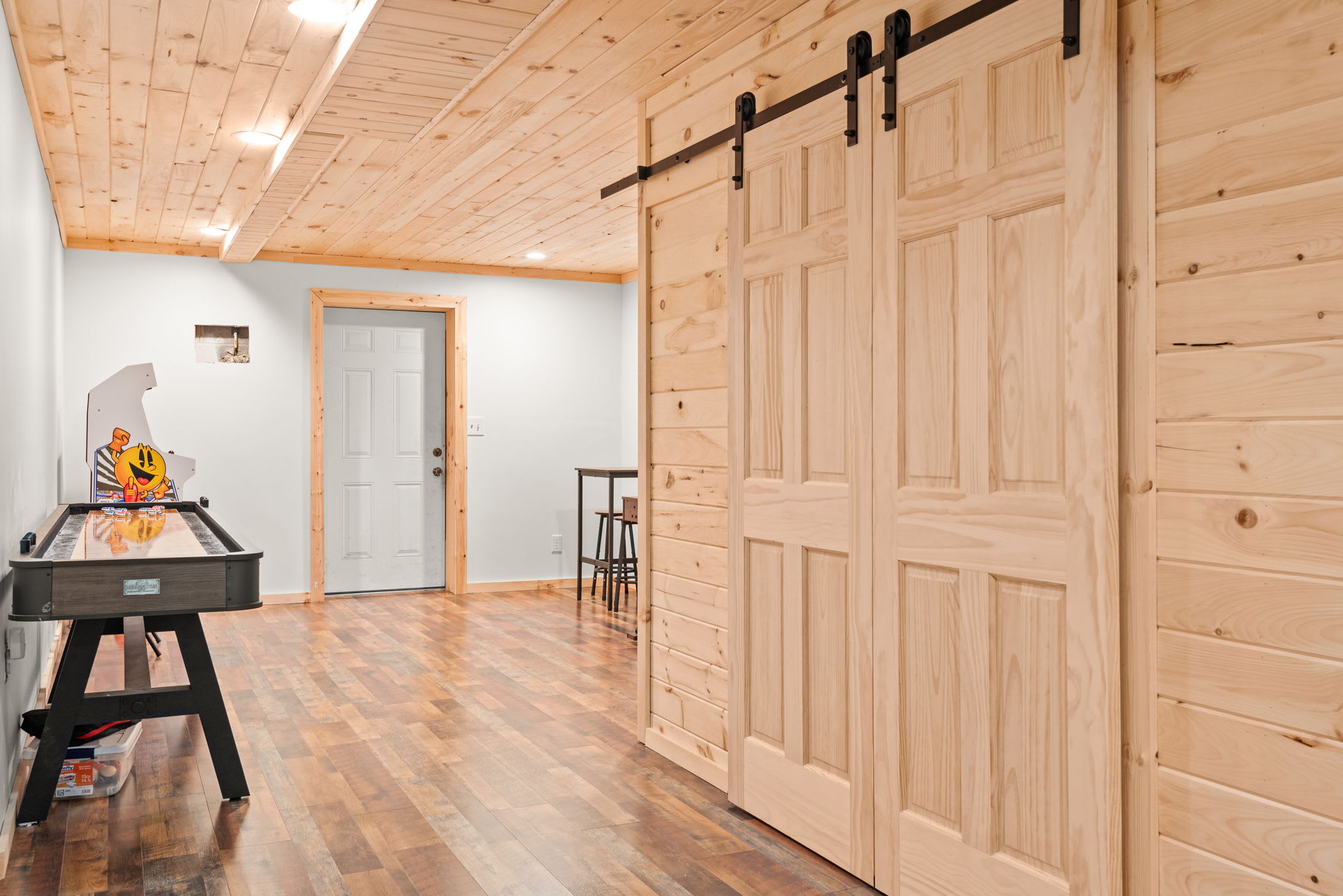 Rustic sliding barn doors add a charming touch to this well-designed entertainment space, seamlessly blending style and function.