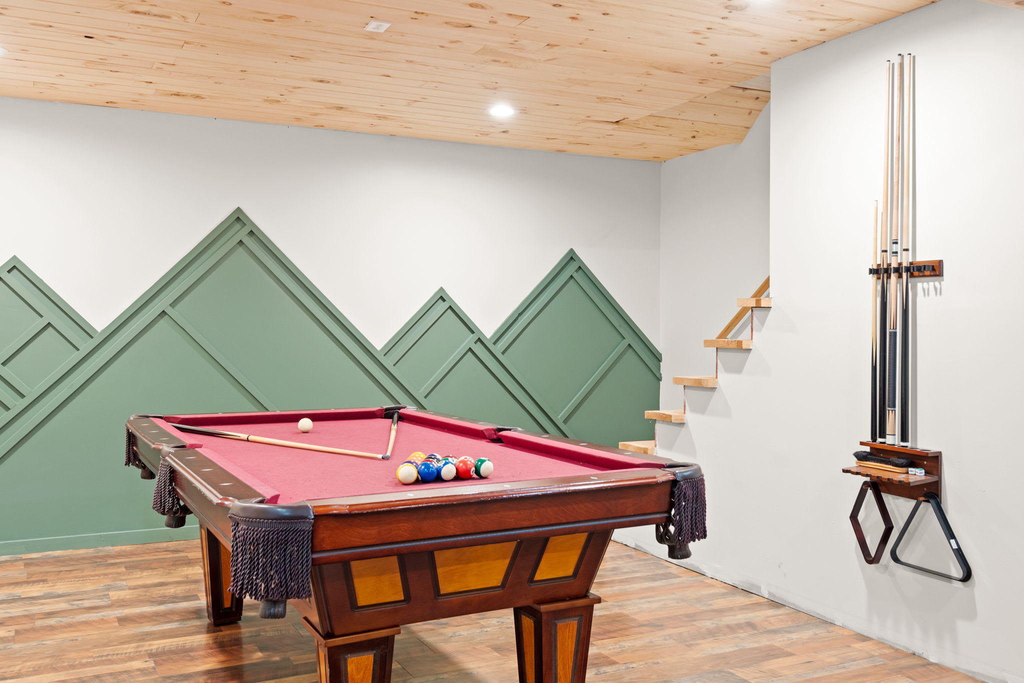 A well-stocked game space with pool cues neatly mounted, creating an inviting and stylish spot for endless entertainment.