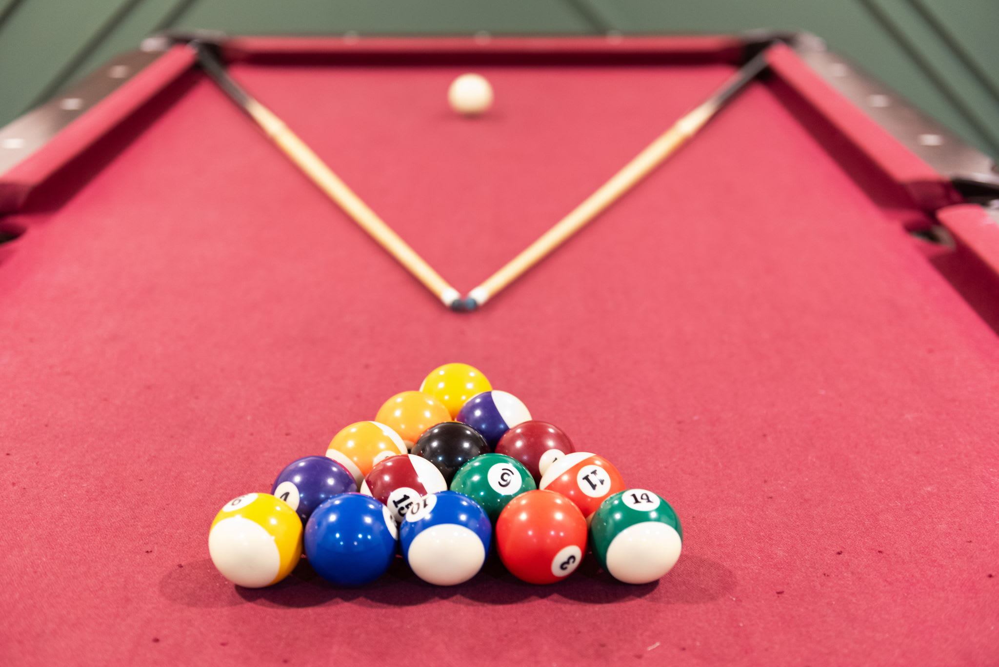 A close-up of the pool table, neatly racked and ready for action. Grab a cue, call your shot, and let the games begin in this stylish and cozy game room.