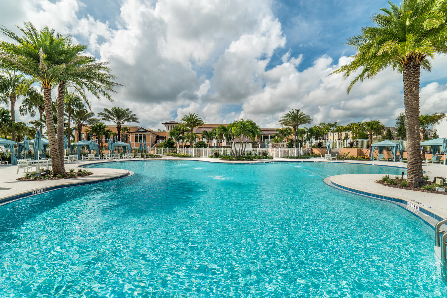Spacious outdoor pool framed by palm trees, perfect for sunny afternoons.