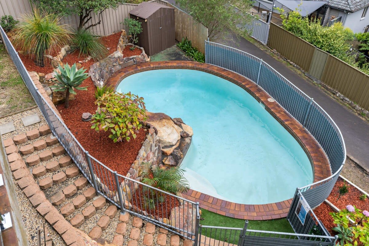 The beautifully landscaped gardens create a picturesque backdrop as you make your way towards the inviting inground pool.
