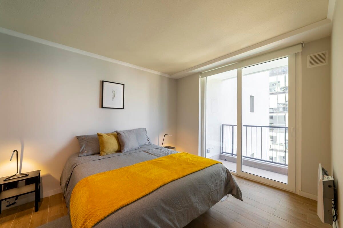 Relax in this cozy bedroom with a private balcony, perfect for enjoying the city views and natural light.