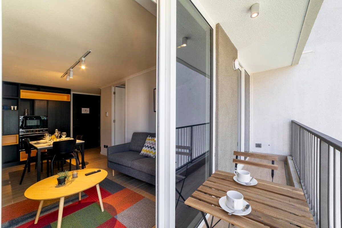 Cozy studio with a vibrant living area and a charming balcony, perfect for enjoying a morning coffee.