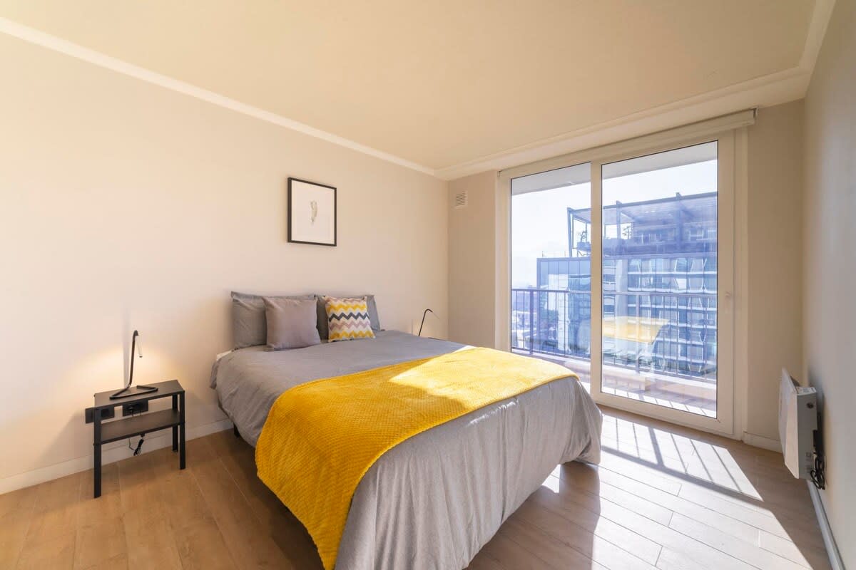 Relax in this bright and cozy bedroom with stunning city views, perfect for a peaceful getaway.